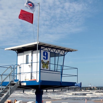 An einem Strand auf der Ostsee-Insel Usedom weht an einem Beobachtungsposten eine rote Fahne, die zeigt, dass Baden derzeit verboten ist.