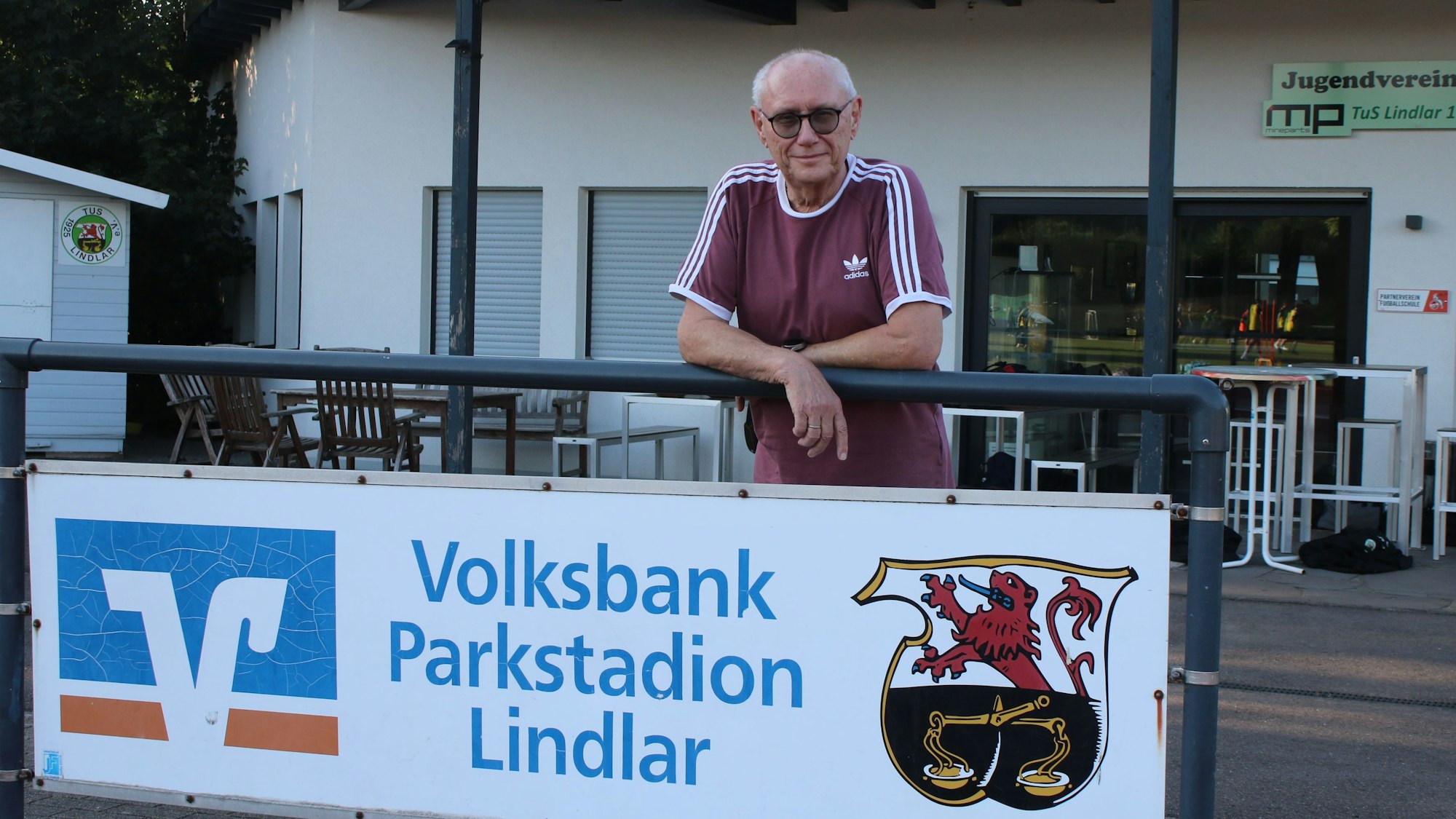 Ein Mann steht vor einem Vereinsheim.