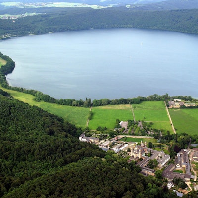 Luftbild von Mendig mit dem Laacher See und dem Kloster Maria Laach in der Eifel. Aufnahme von 2004.