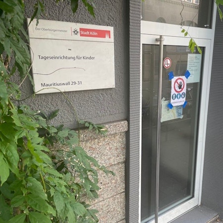 Eingang der städtischen Kita Maurituswall mit Warnschild