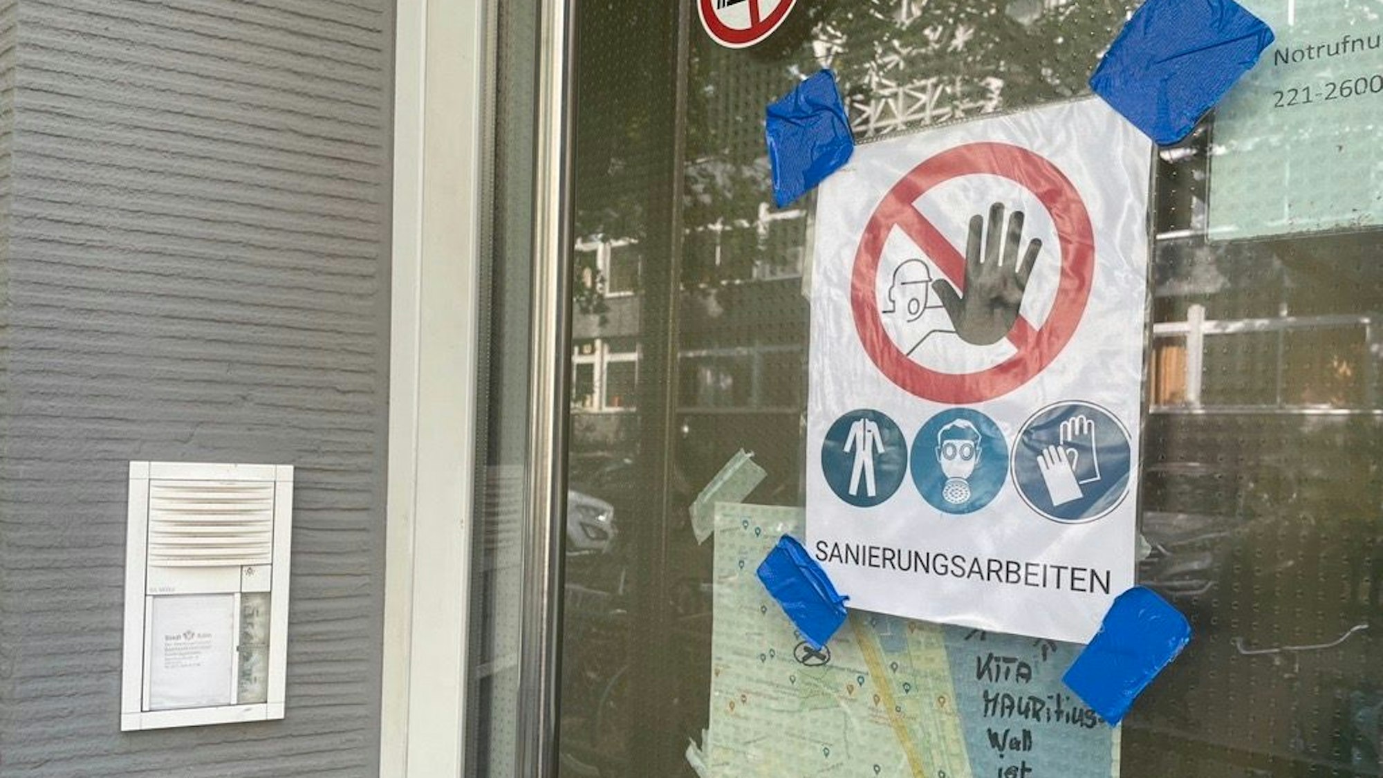 Eingangstür zur Kita Mauritiuswall mit einem Schild, auf dem „Sanierungsarbeiten“ zu lesen ist.
