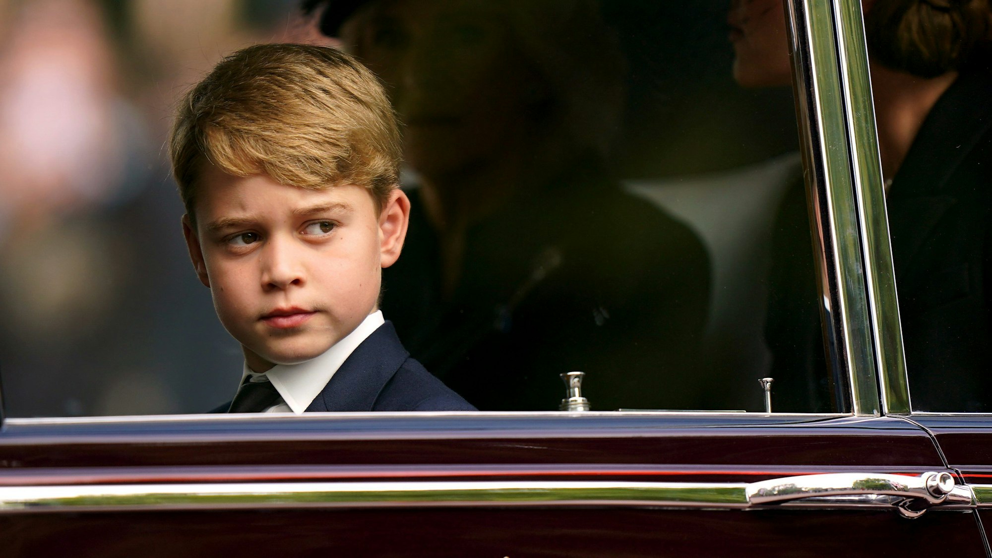 Prinz George sitzt bei der feierlichen Prozession nach dem Staatsakt vor der Beisetzung von Königin Elizabeth II. in einer Limousine.