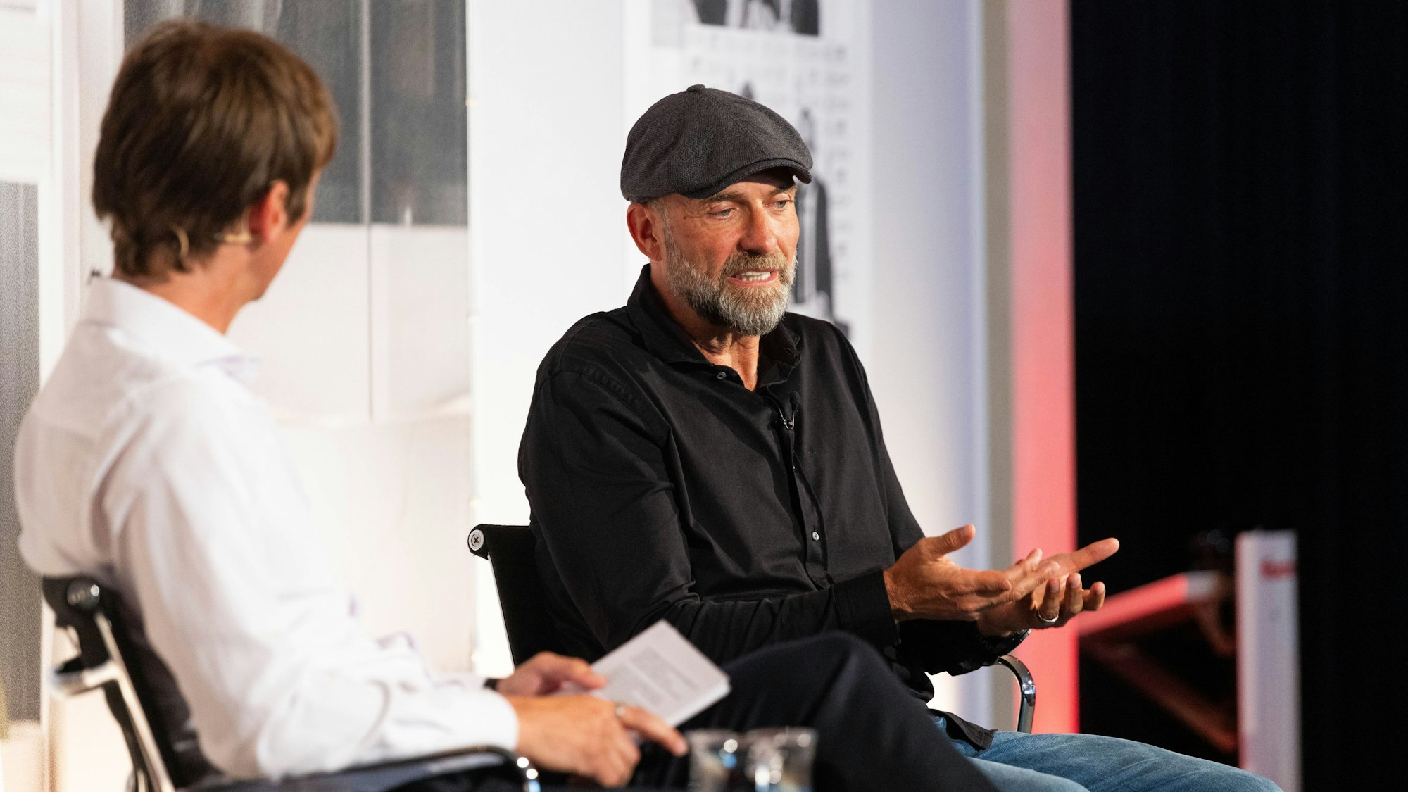 Jürgen Klopp sitzt während eines Interviews neben Toni Tomic, Sportjournalist