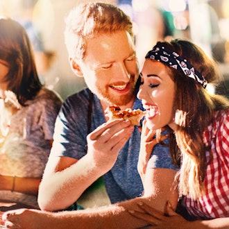 Junges Paar beim Pizzaessen nach einer Party.