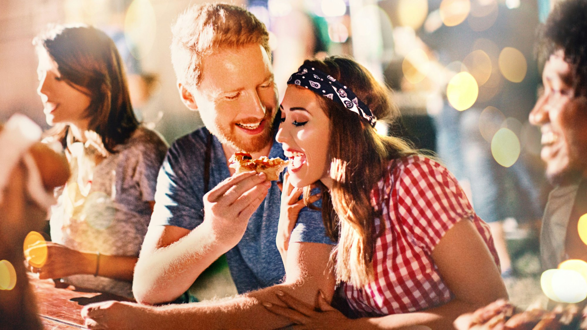 Junges Paar beim Pizzaessen nach einer Party.