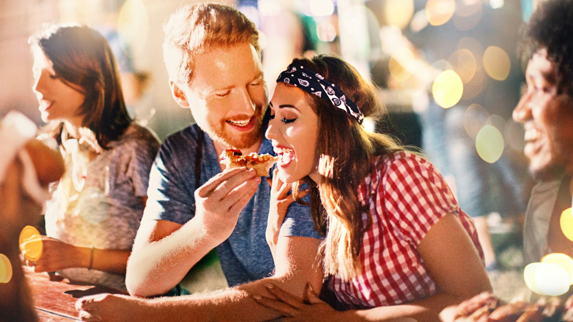 Junges Paar beim Pizzaessen nach einer Party.