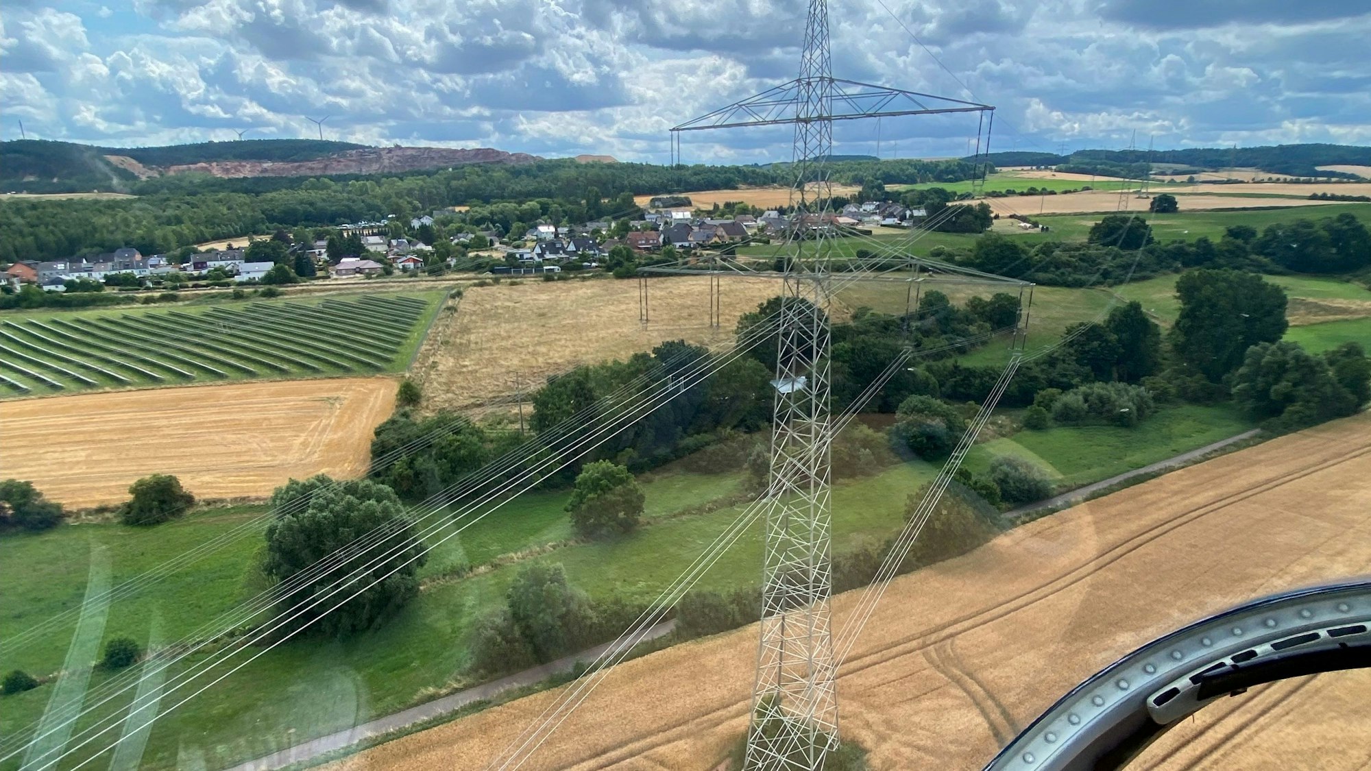 Das Bild zeigt einen Blick aus einem Hubschrauber auf eine 380-kV-Stromleitung bei Kalenberg.