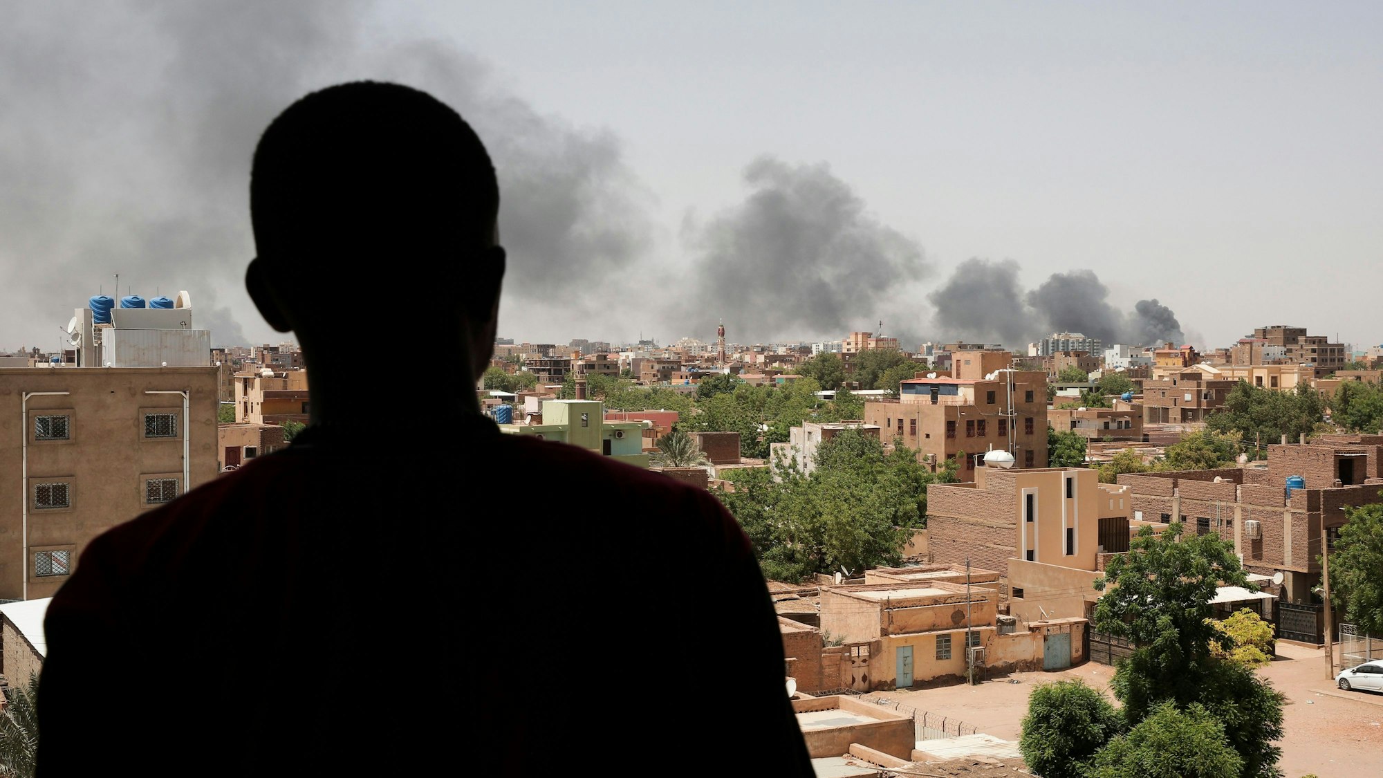 Sudan, Khartum: Ein Mann blickt auf die Stadt Khartum, wo schwarzer Rauch aufsteigt. (Symbolbild)