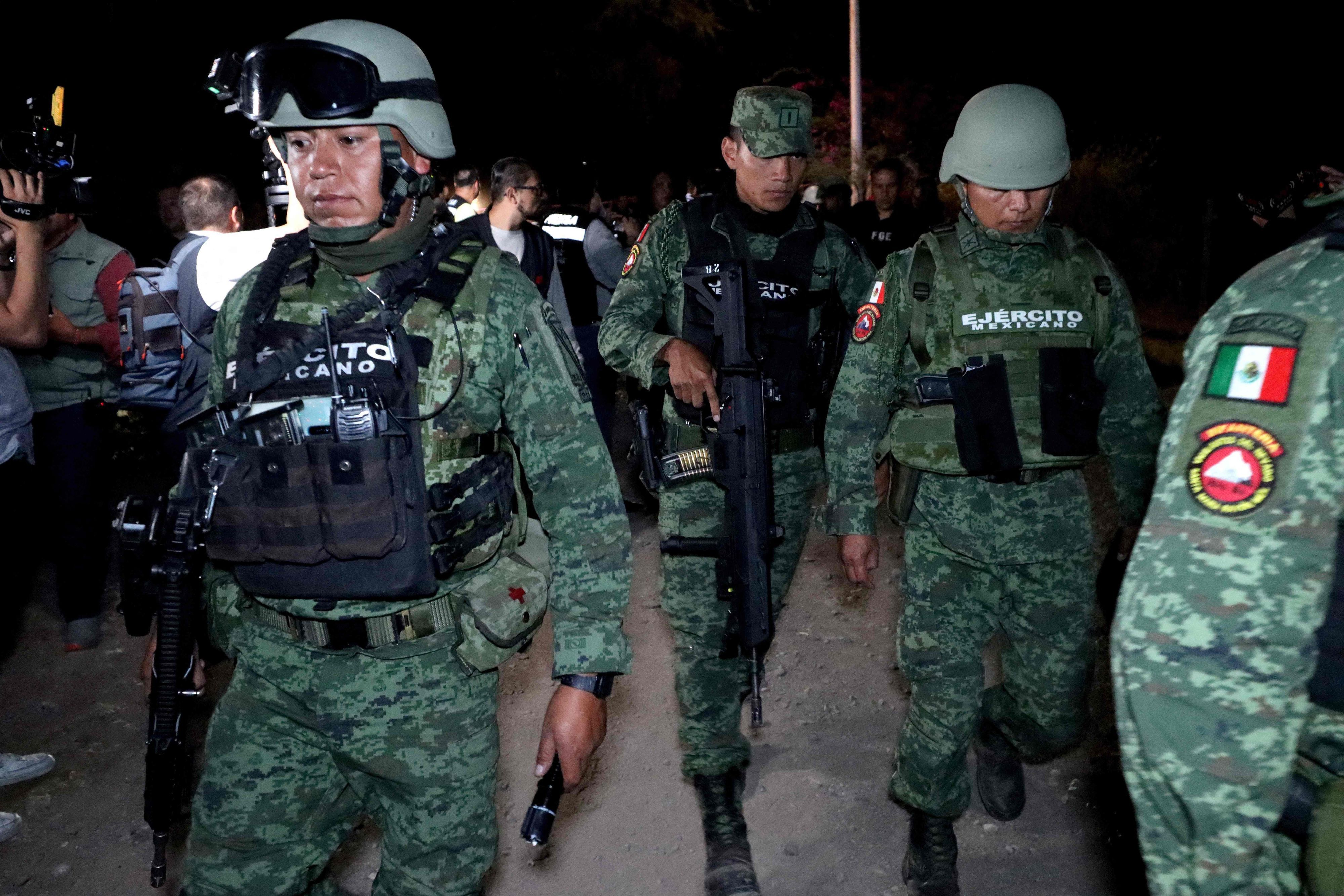 Mehrere mexikanische Soldaten marschieren bei Nacht.