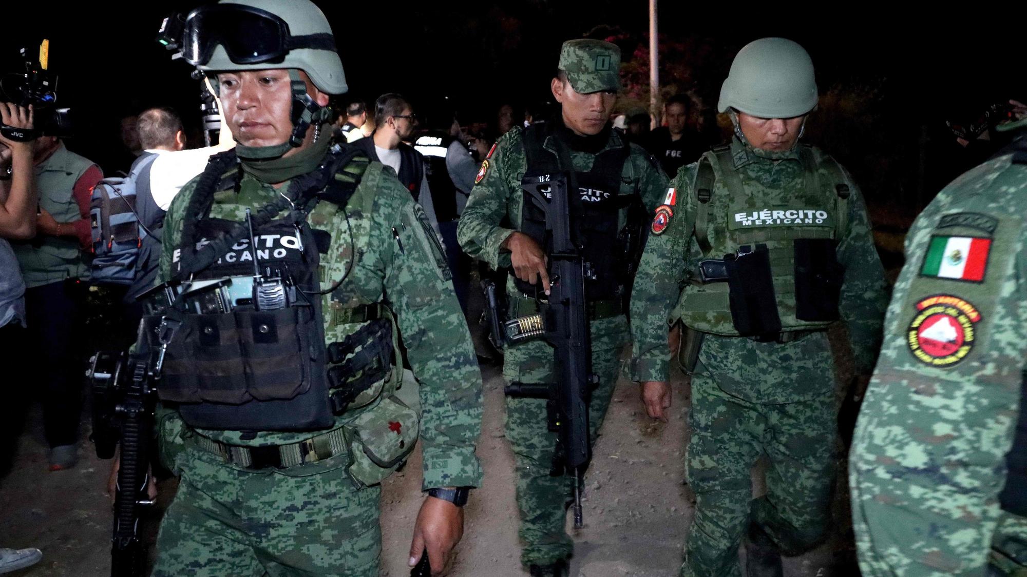 Mehrere mexikanische Soldaten marschieren bei Nacht.