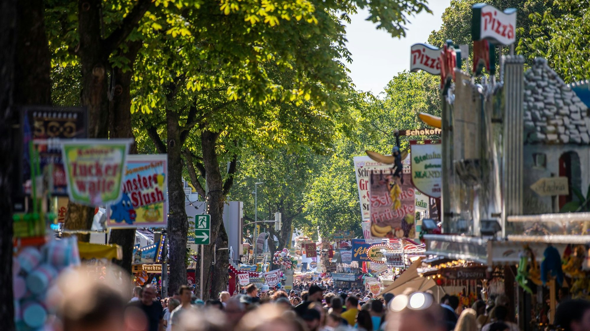 Besucher tummeln sich zwischen Kirmes-Ständen.