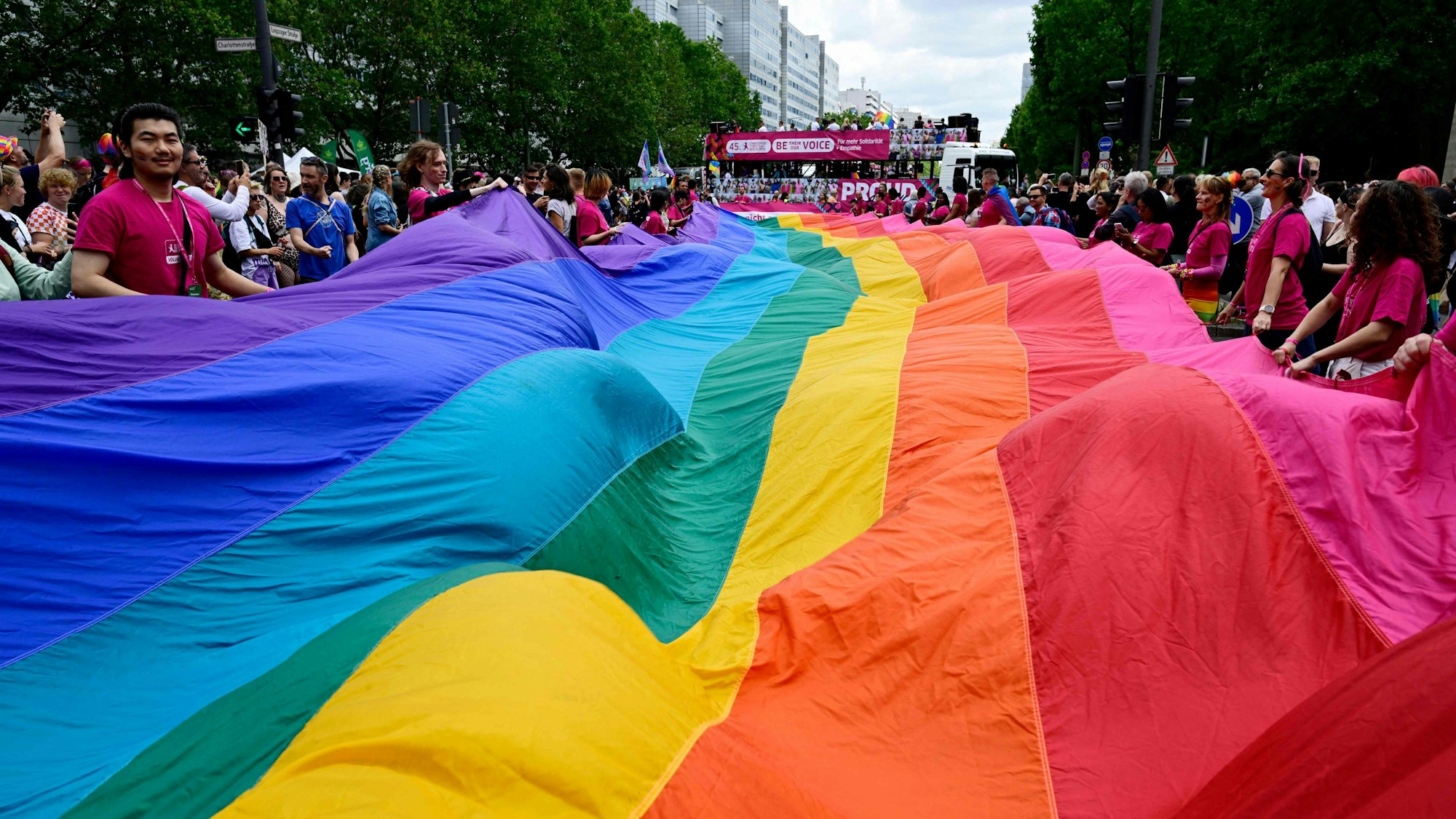 Participants carry a giant rainbow banner at the start of the convoi of the yearly Christopher Street Day (CSD) parade in Berlin on July 22, 2023. The 45th Christopher Street Day Parade takes place on July 22 under the motto 'Be their voice - and ours! ... for more empathy and solidarity'. (Photo by John MACDOUGALL / AFP)