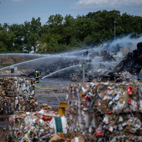 Das Bild zeigt Altpapierballen, die auf dem Gelände von Smurfit Kappa in Brand geraten sind. Die Feuerwehr löscht aus zahlreichen Strahlrohren.