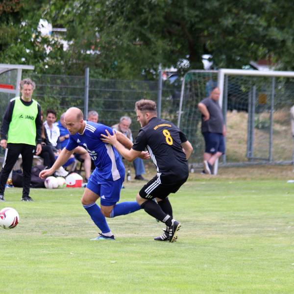 Weilerswists Felix Kortholt zieht an Luca Riedling vorbei. Im Hintergrund beobachten Trainer Horst Bartz im gelben Leibchen und die Zuschauer die Aktion.