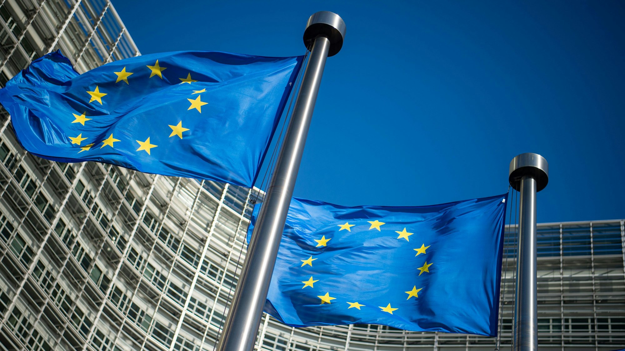 ARCHIV - 10.06.2019, Belgien, Brüssel: Flaggen der Europäischen Union wehen im Wind vor dem Berlaymont-Gebäude, dem Sitz der Europäischen Kommission.