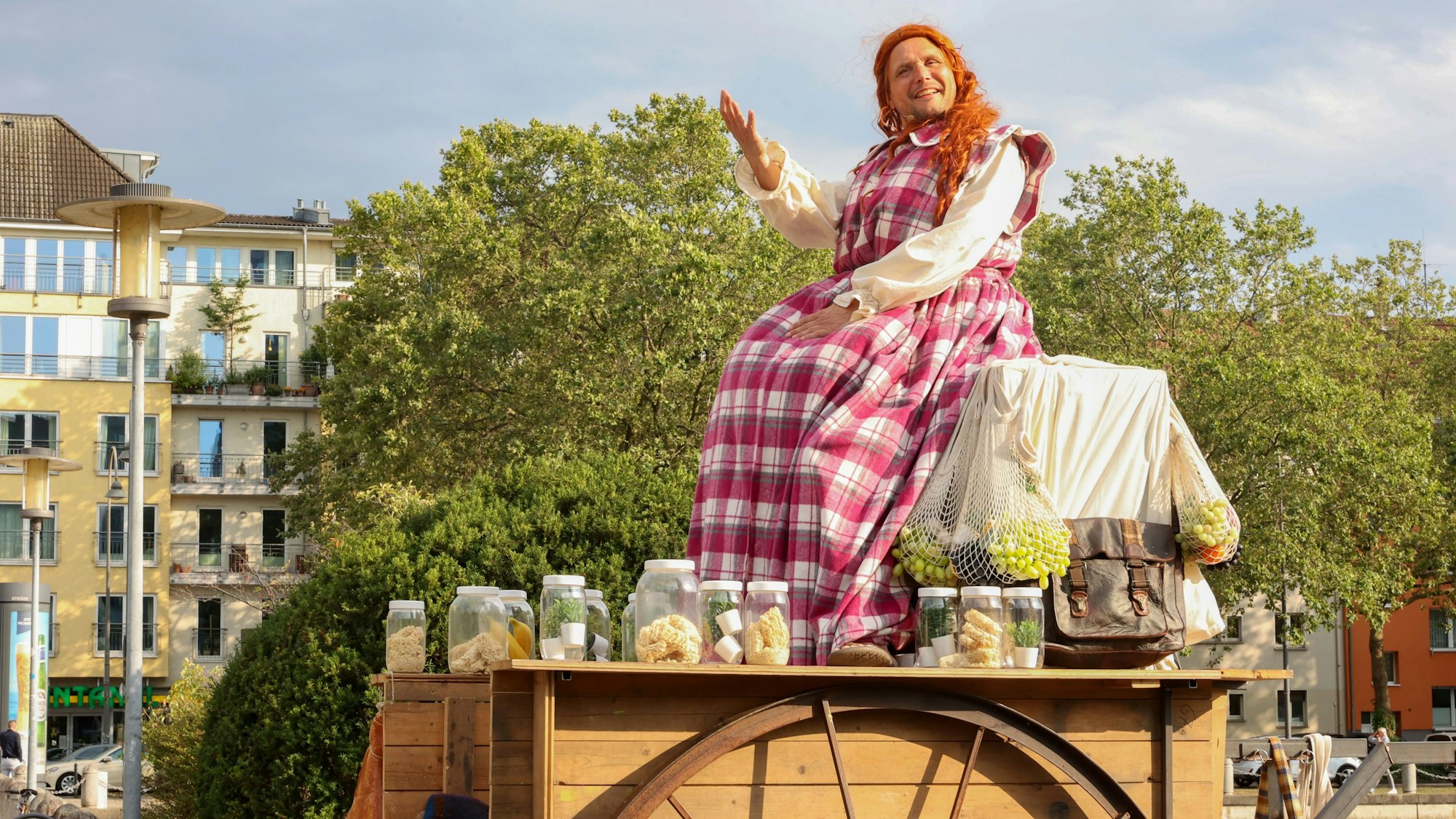 Ein Mann sitzt mit Kochschürze auf einem Wagen.