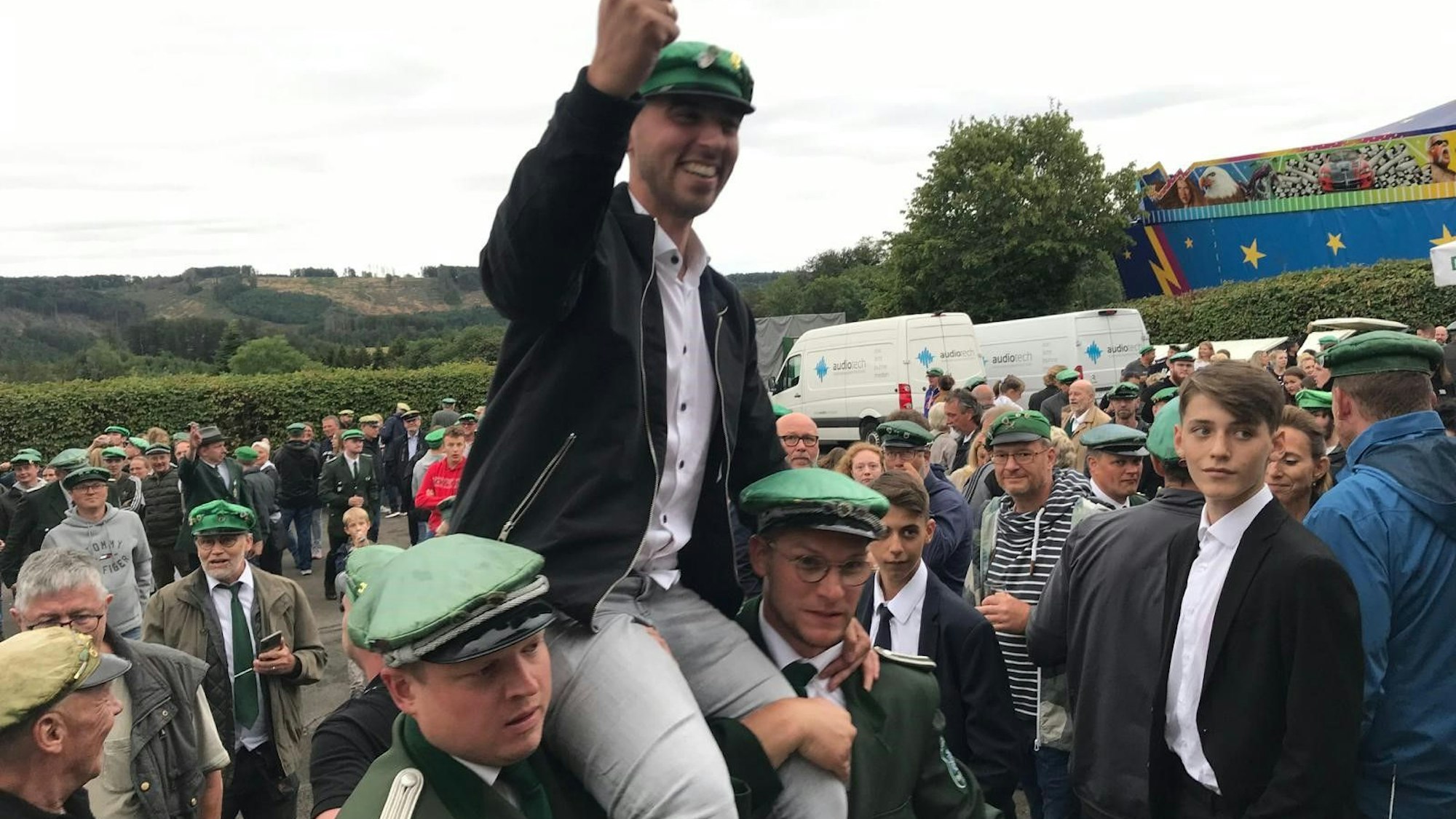 Mehrere Schützenbrüder heben einen ihrer Schützen auf Schultern in die Höhe.