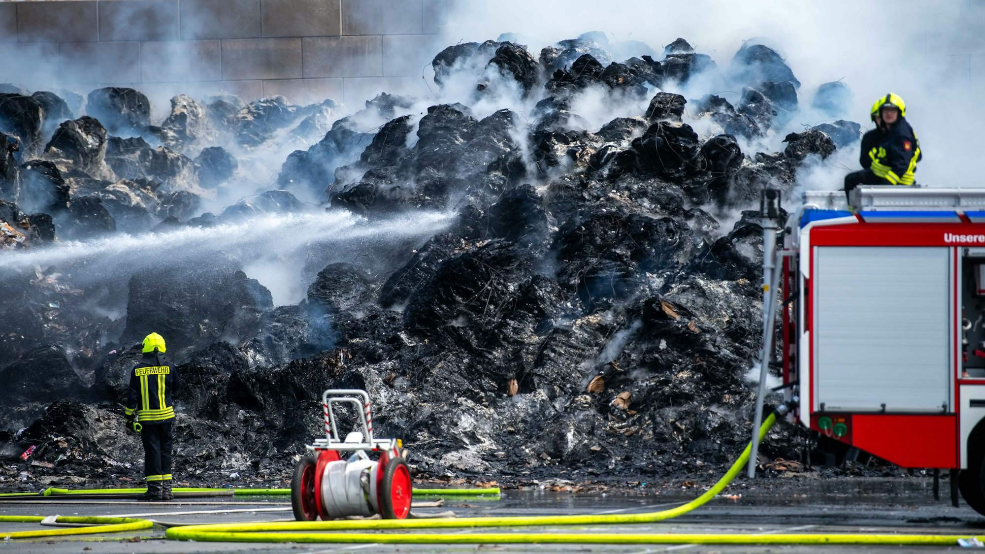 Viel ist von den Papierballen nicht mehr übrig. Zu sehen ist ein qualmender Haufen Papier.