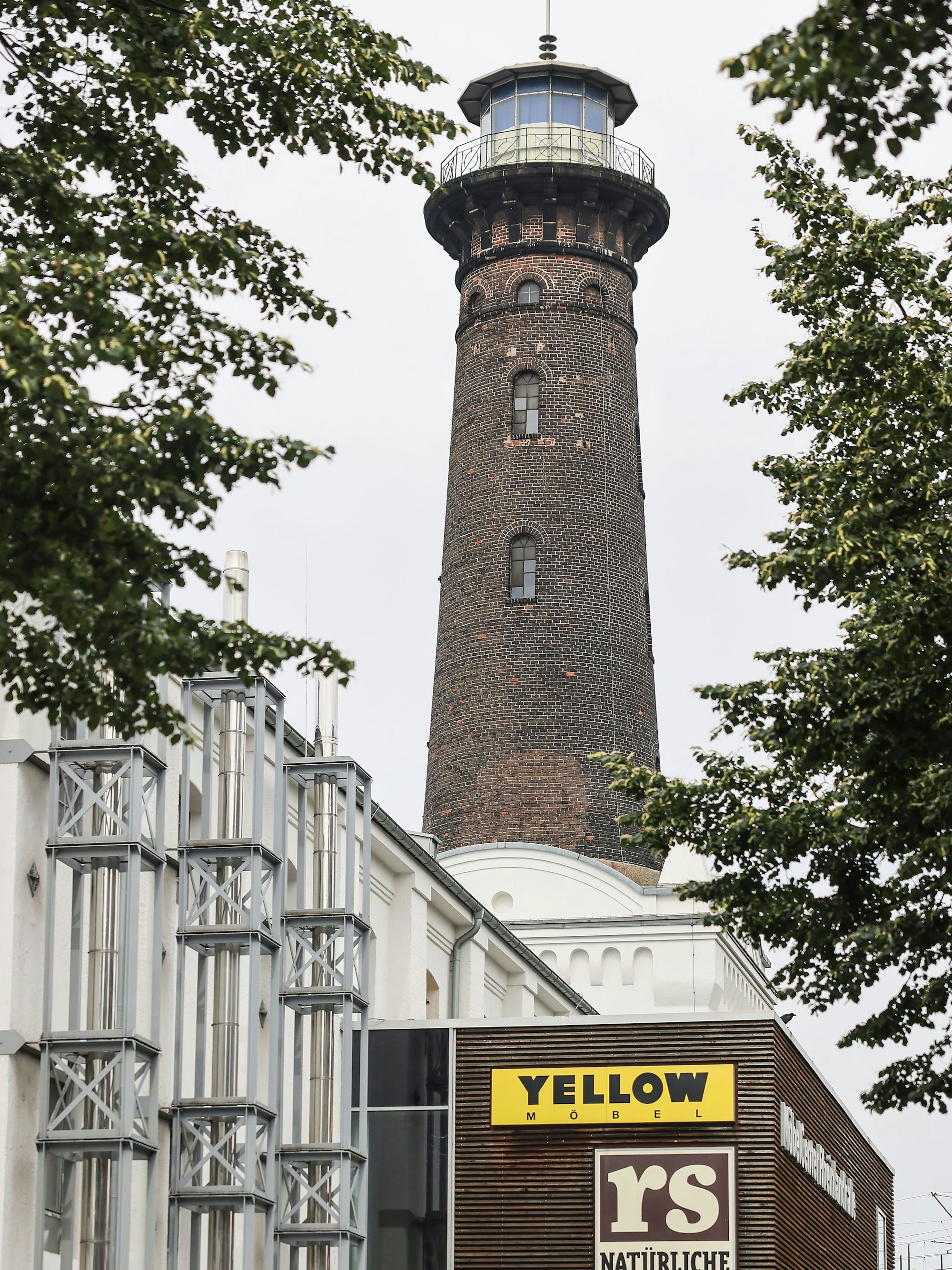 Der Leuchtturm in Köln Ehrenfeld steht über dem Gebäude eines Möbelhauses.