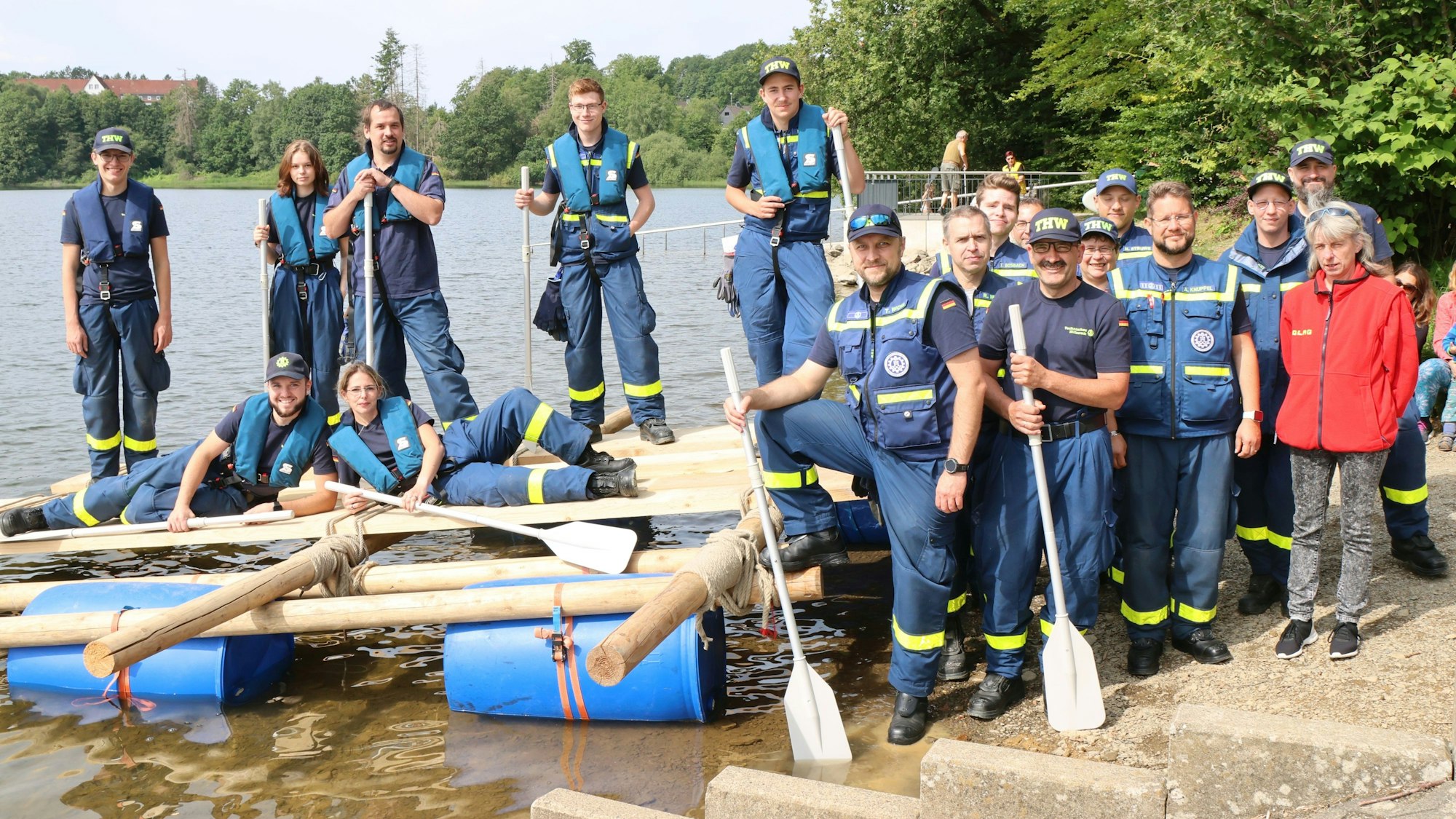 Eine THW-Gruppe steht auf und um ein selbstgebautes Floß herum.