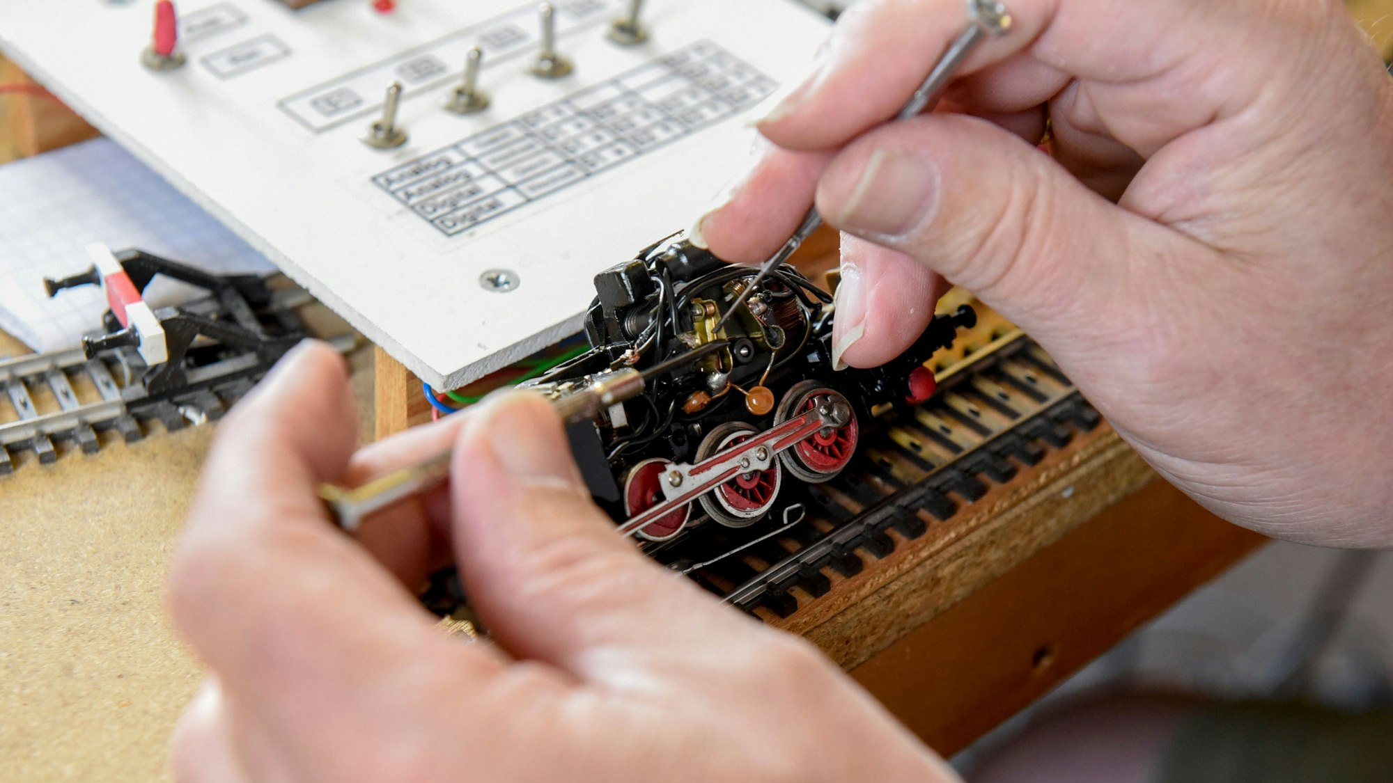 Auf dem Foto ist zu sehen, wie Wolfgang Mahrt einen Dampfloknachbau unter die Lupe nimmt.