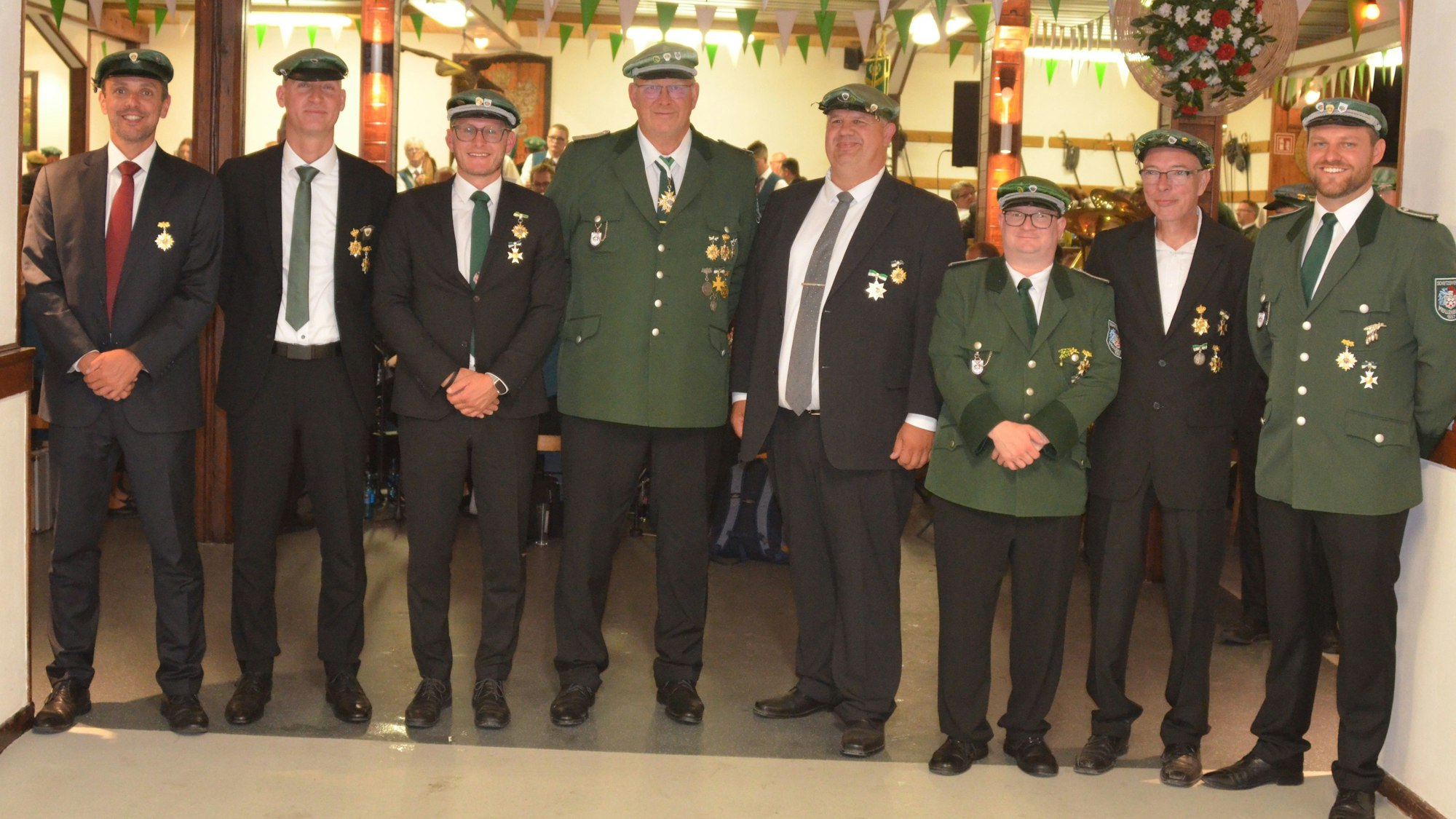 Mehrere Schützenbrüder stehen in Uniform und mit Orden nebeneinander.