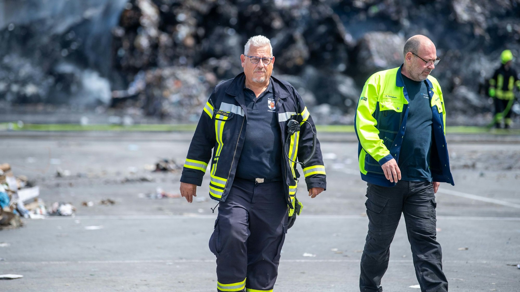 Zwei Männer, unter anderem Einsatzleiter Jörg Körtgen, verlässt den Einsatzort.