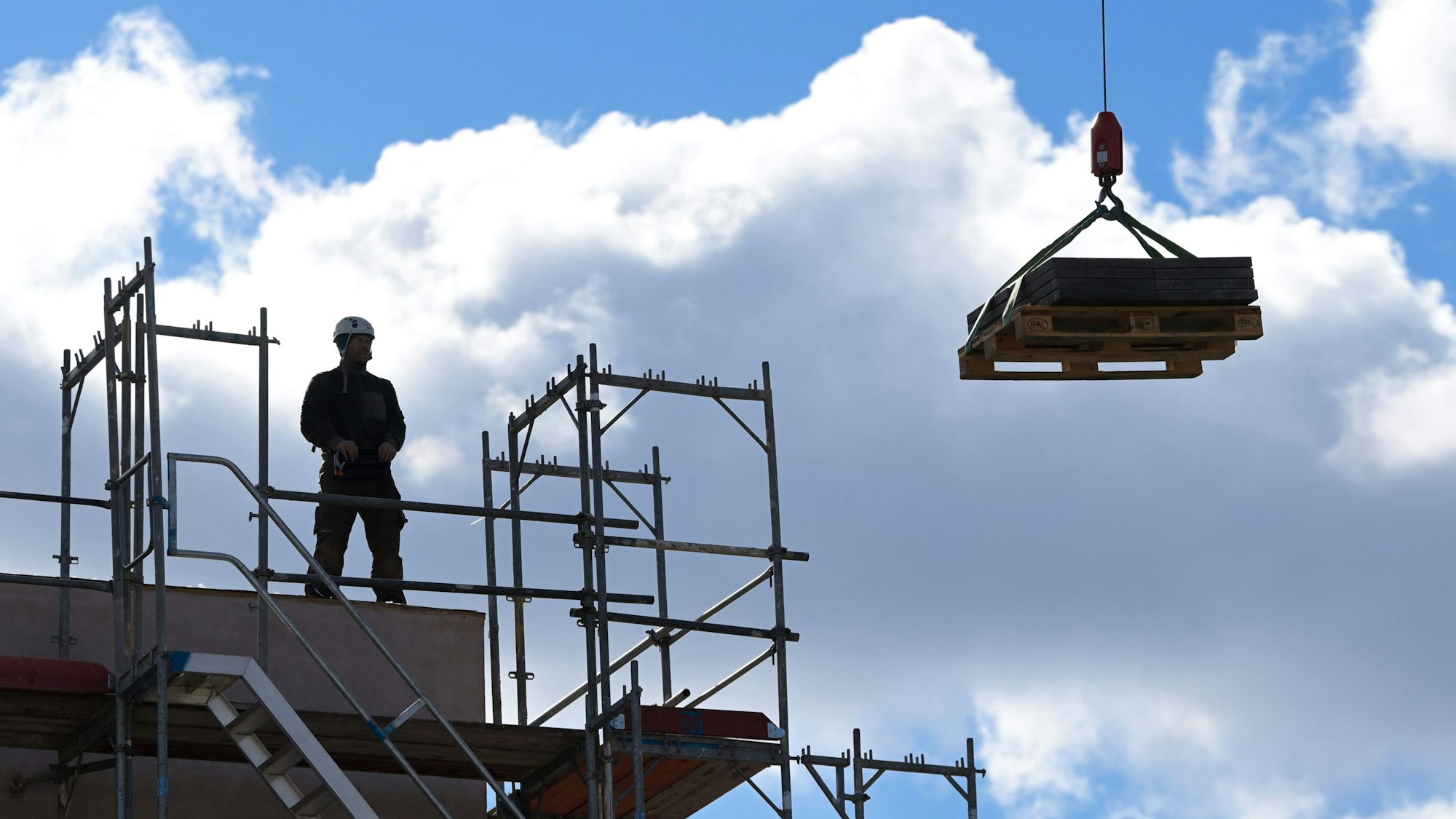 Ein Mann steht auf einem im Bau befindlichen Gebäude.