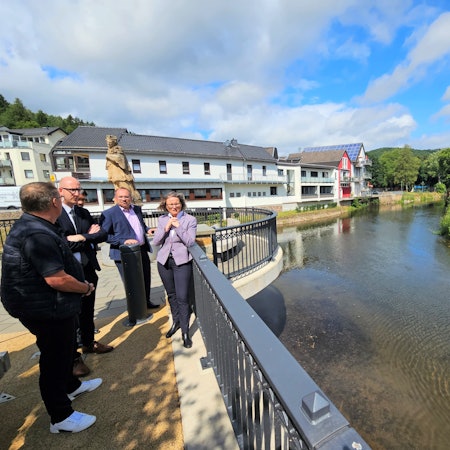 Mehrere Männer und eine Frau stehen am Zusammenfluss von Urft und Olef in Gemünd.