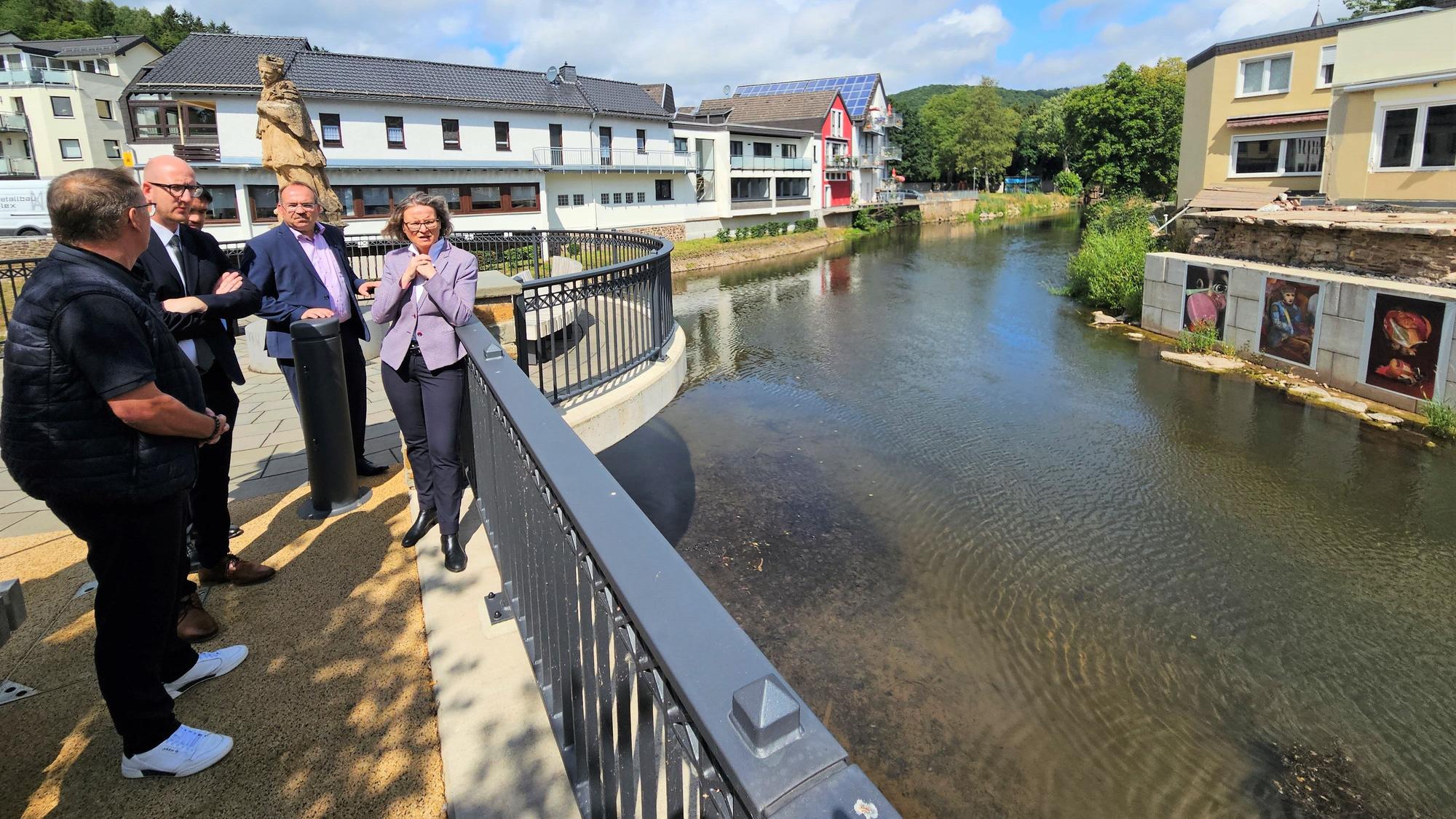 Mehrere Männer und eine Frau stehen am Zusammenfluss von Urft und Olef in Gemünd.