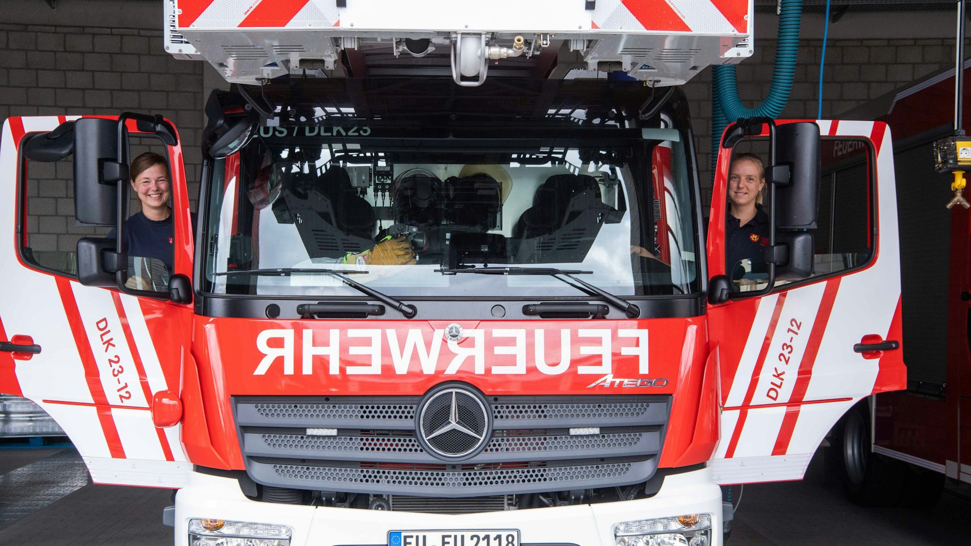 Zwei Feuerwehrfrauen steigen in die Drehleiter der Euskirchener Feuerwehr ein.