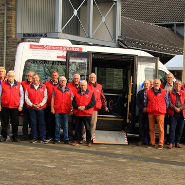 Fahrerinnen und Fahrer des Bürgerbusvereins Kürten stehen vor ihrem Bus.