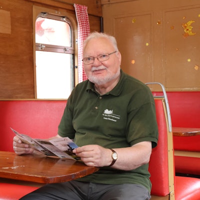 Volker Eisenhauer sitzt an einem Tisch in einem alten Eisenwagenwagon.