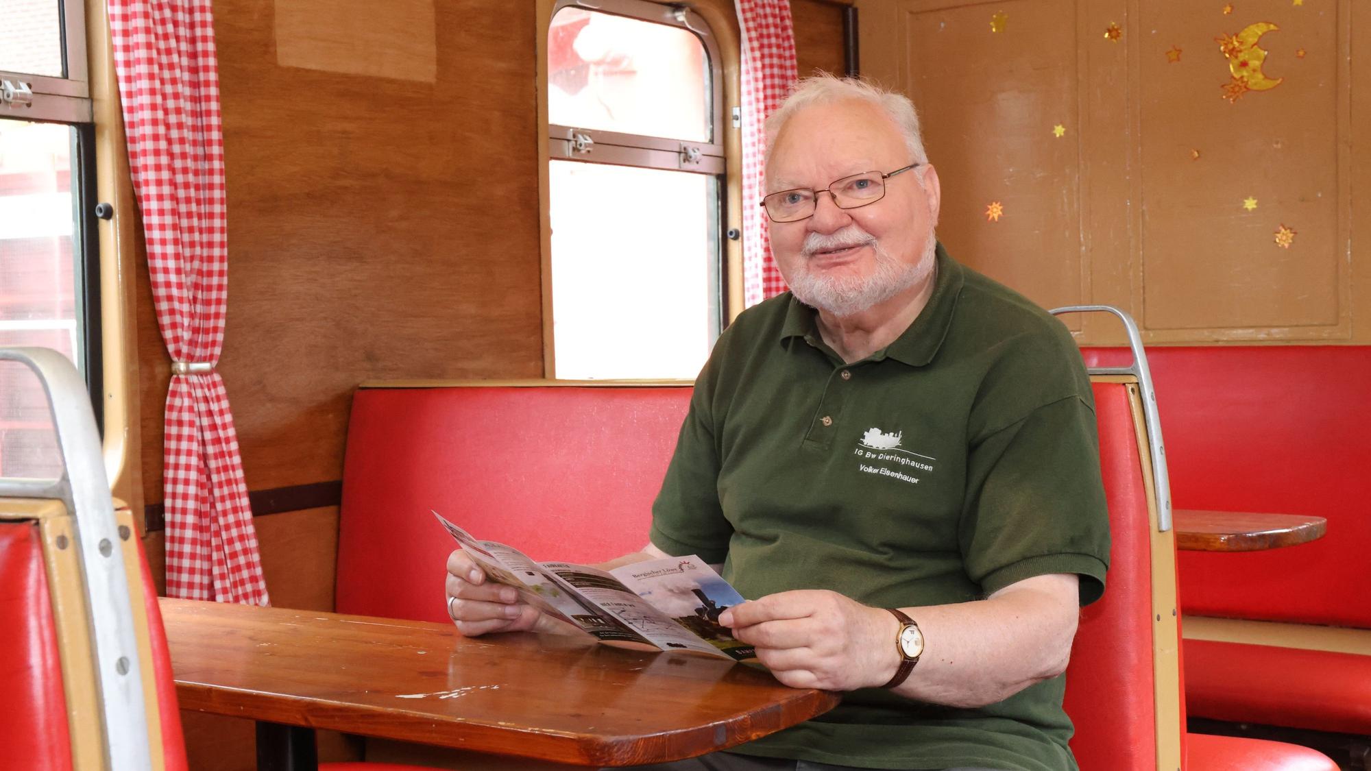 Volker Eisenhauer sitzt an einem Tisch in einem alten Eisenwagenwagon.