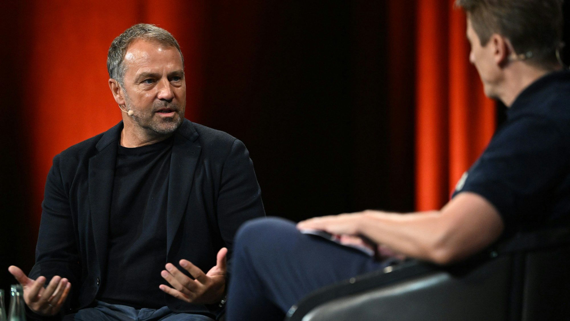 Hansi Flick (l), Trainer der deutschen Fußballnationalmannschaft, mit Moderator Michael Leopold, nimmt beim Internationalen Trainer-Kongress der BDFL, den der Bund Deutscher Fußball-Lehrer (BDFL) veranstaltet, an einem Bühnengespräch teil.