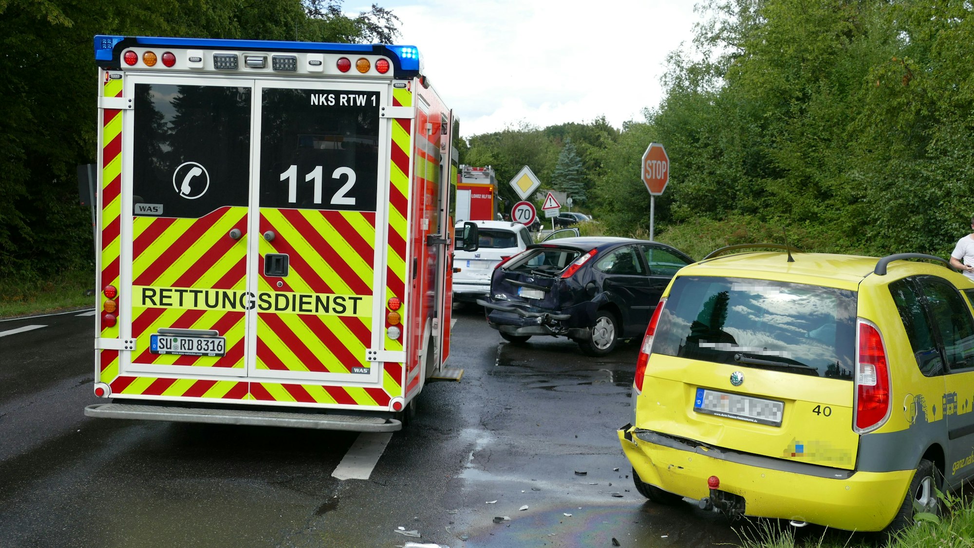 Mehrere Unfallwagen stehen auf einer Straße. Ein Krankenwagen ist vor Ort.