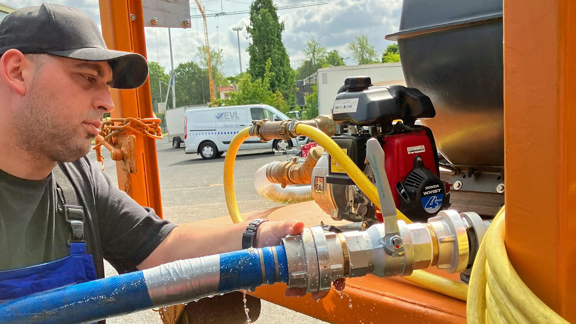 Ein Mann an einer Wasserpumpe.