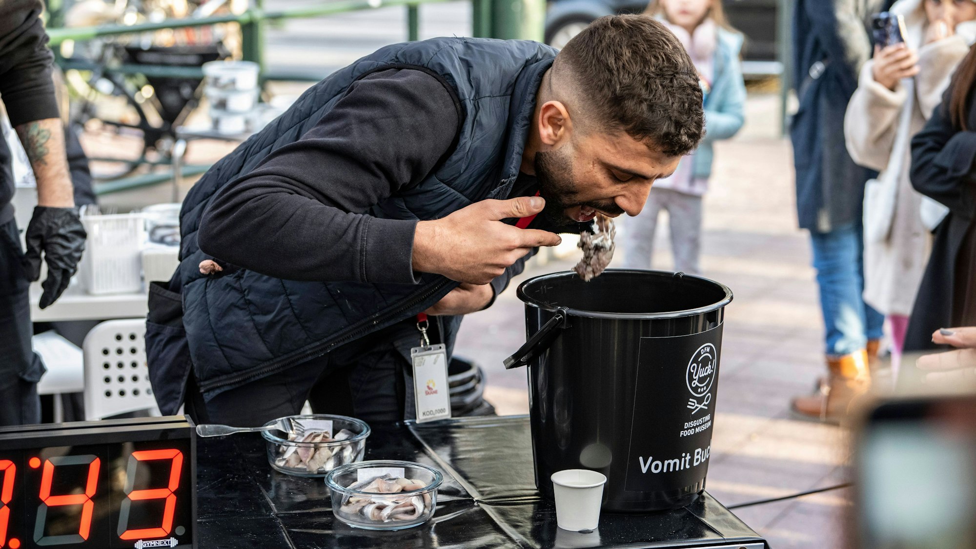 Ein Teilnehmer beim Surströmming-Wettessen spuckt den Fisch wieder aus.