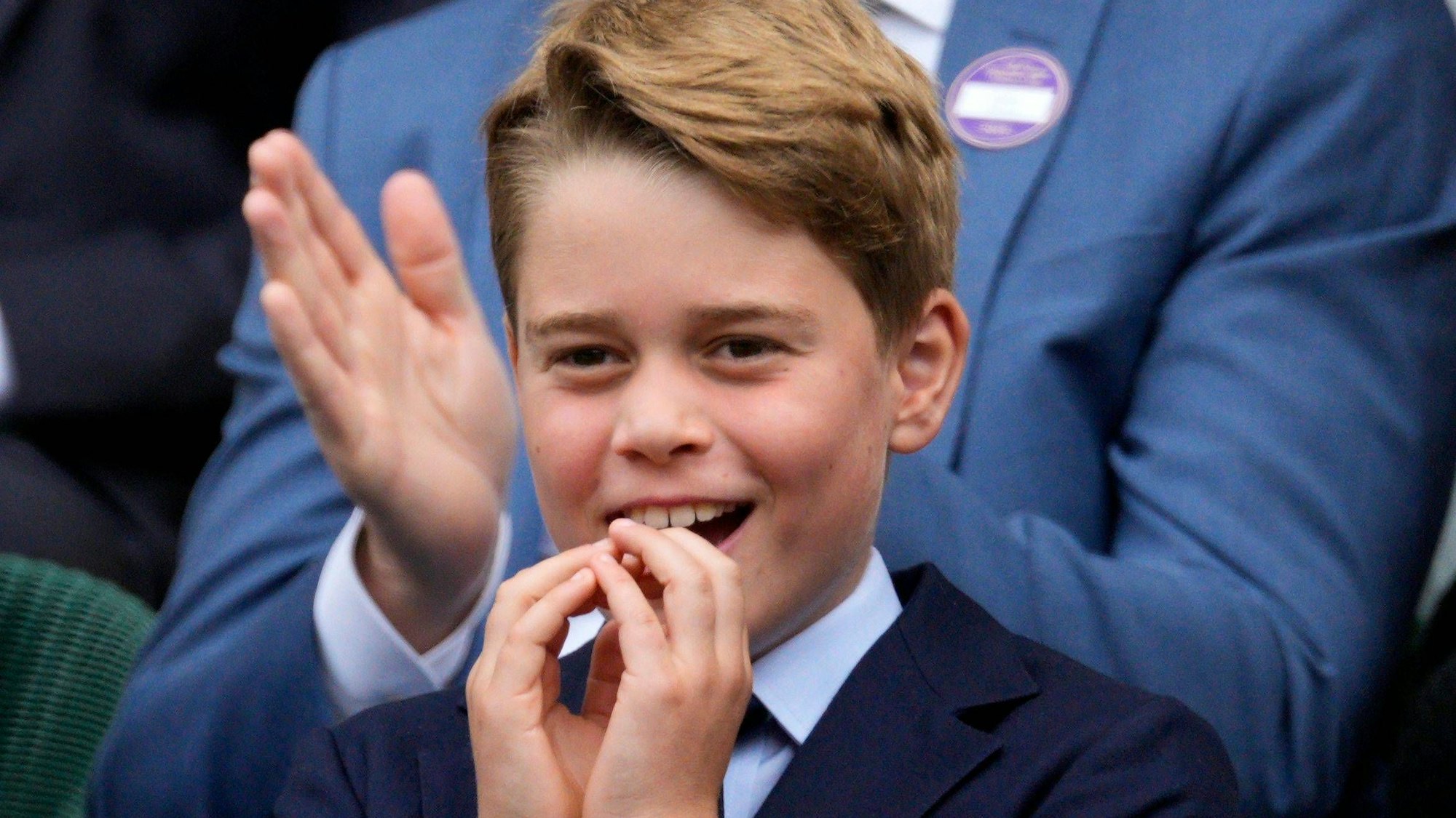 Prinz George lacht und hält sich die Hände vor den Mund.