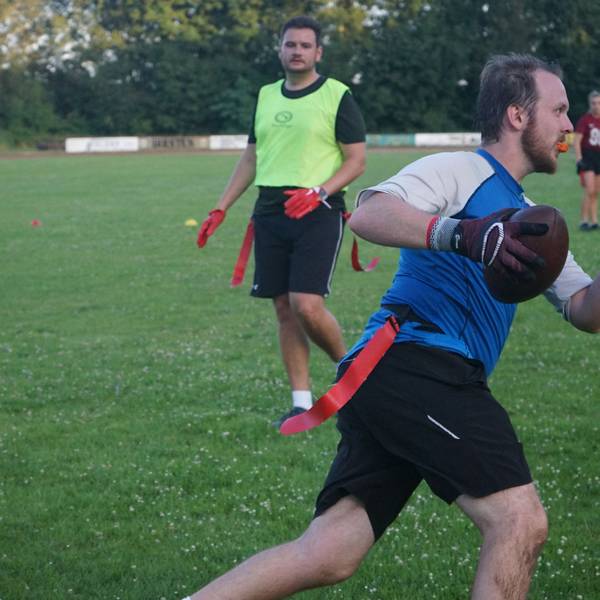 Das Bild zeigt einen Spieler der Raccoons, der mit einem Football in der Hand über den Sportplatz läuft.