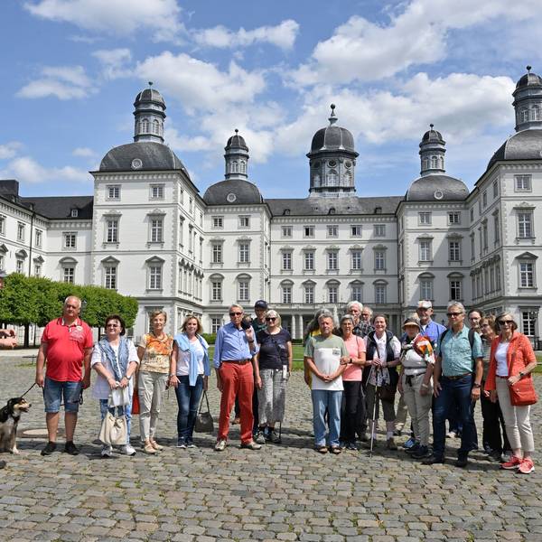 Eine Wandergruppe steht im Innenhof von Schloss Bensberg.
