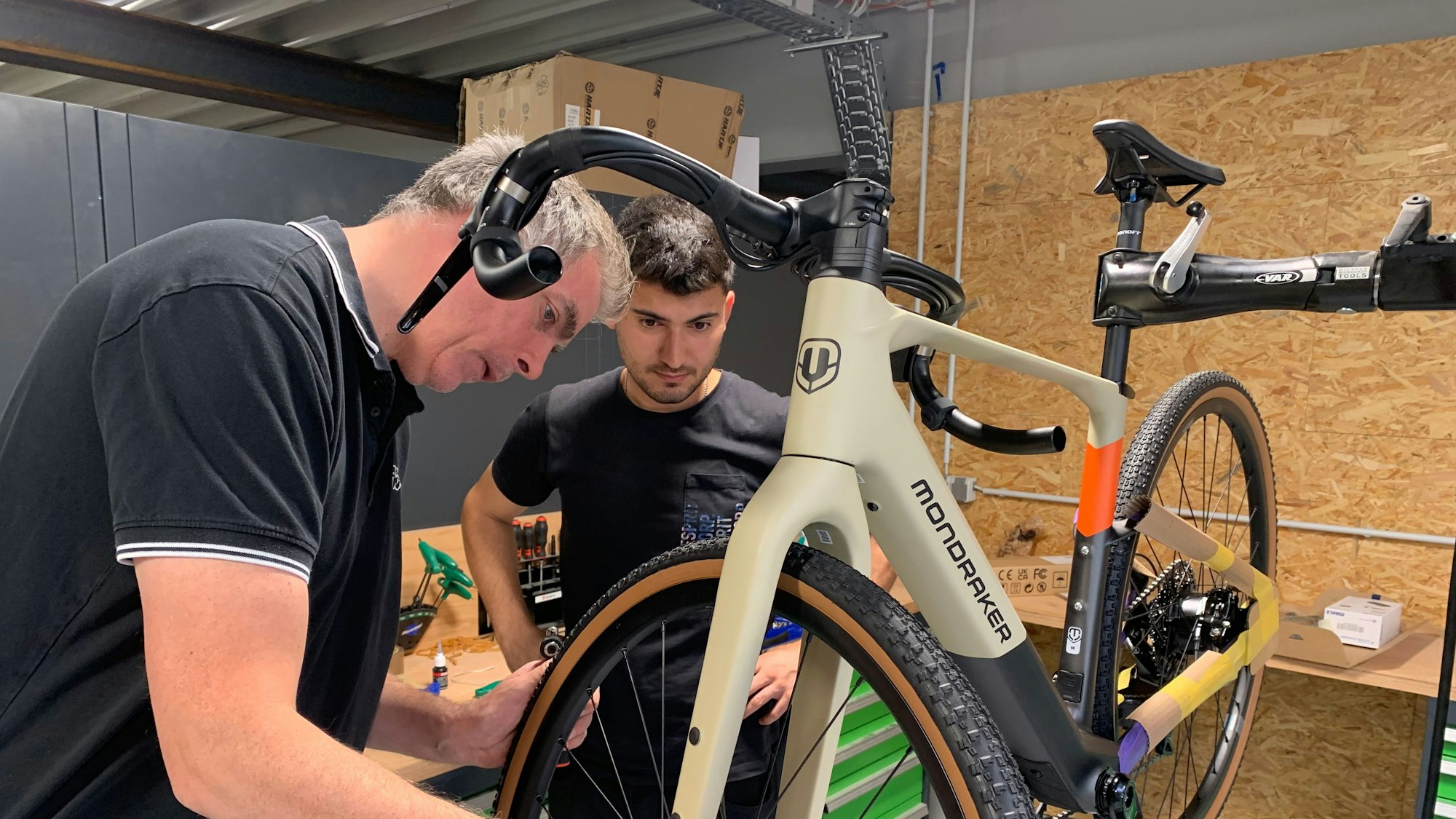 Das Firmengebäude der Firma Veloland ist fast fertig. Zweiradmechaniker bei der Endmontage eines Fahrrades.