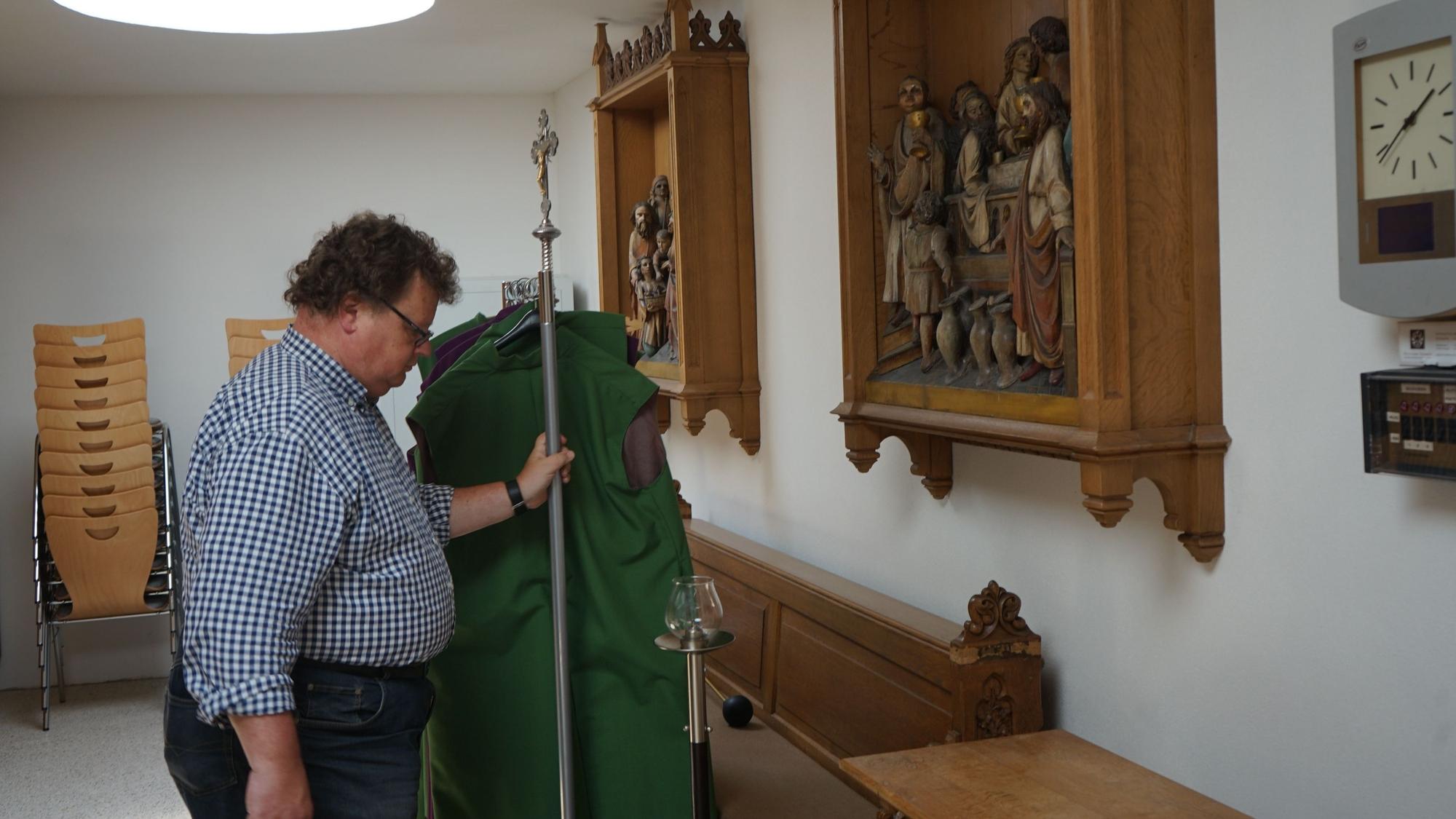 Das Bild zeigt Ludger Möers in der Sakristei der Kapelle St. Albanus und Leonhardus. Heiligenfiguren hängen an der Wand.