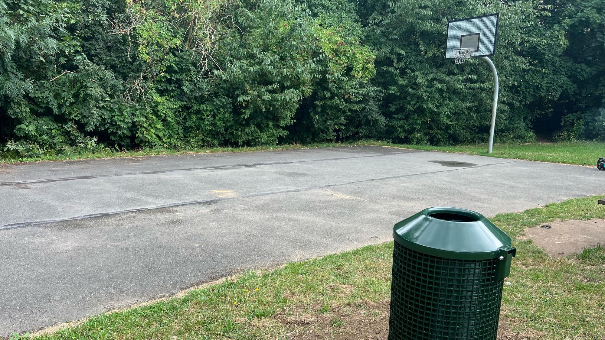 Neben dem Basketballfeld steht nun auch ein grüner Mülleimer.