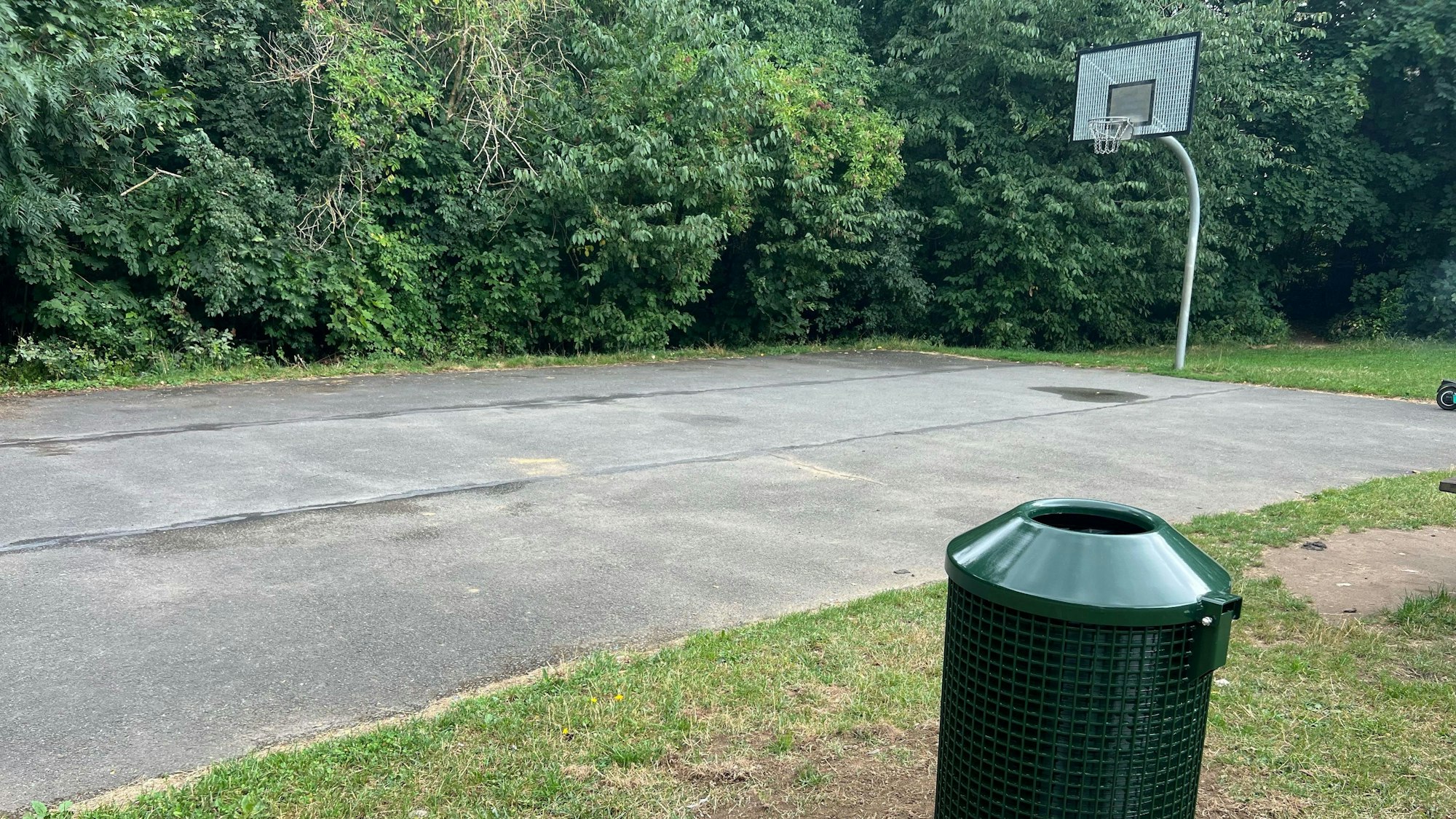 Neben dem Basketballfeld steht nun auch ein grüner Mülleimer.