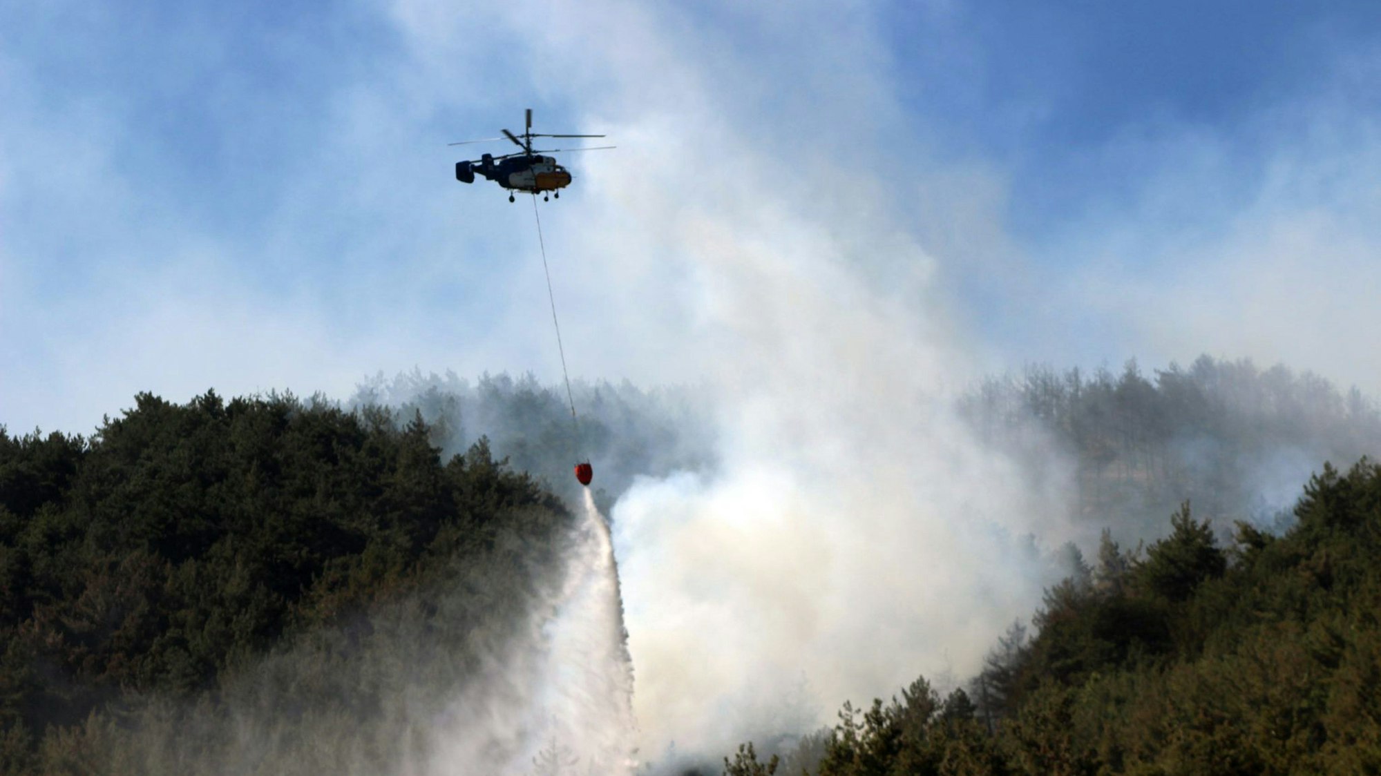 Türkei, Belen: Ein Hubschrauber arbeitet an der Eindämmung eines Waldbrandes.