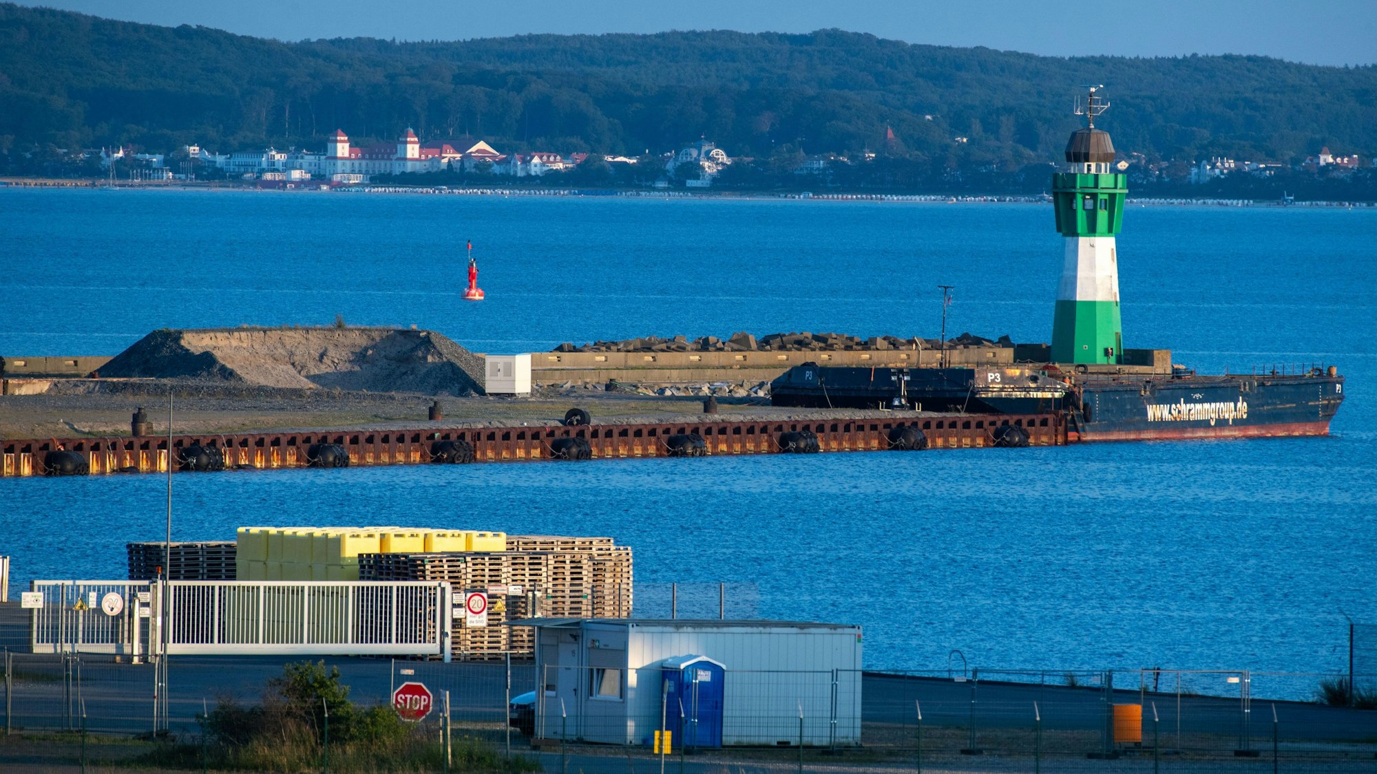 Blick auf die Mole des Hafen Mukran im Hintergrund ist das Ostseebad Binz mit dem Kurhaus zu sehen.