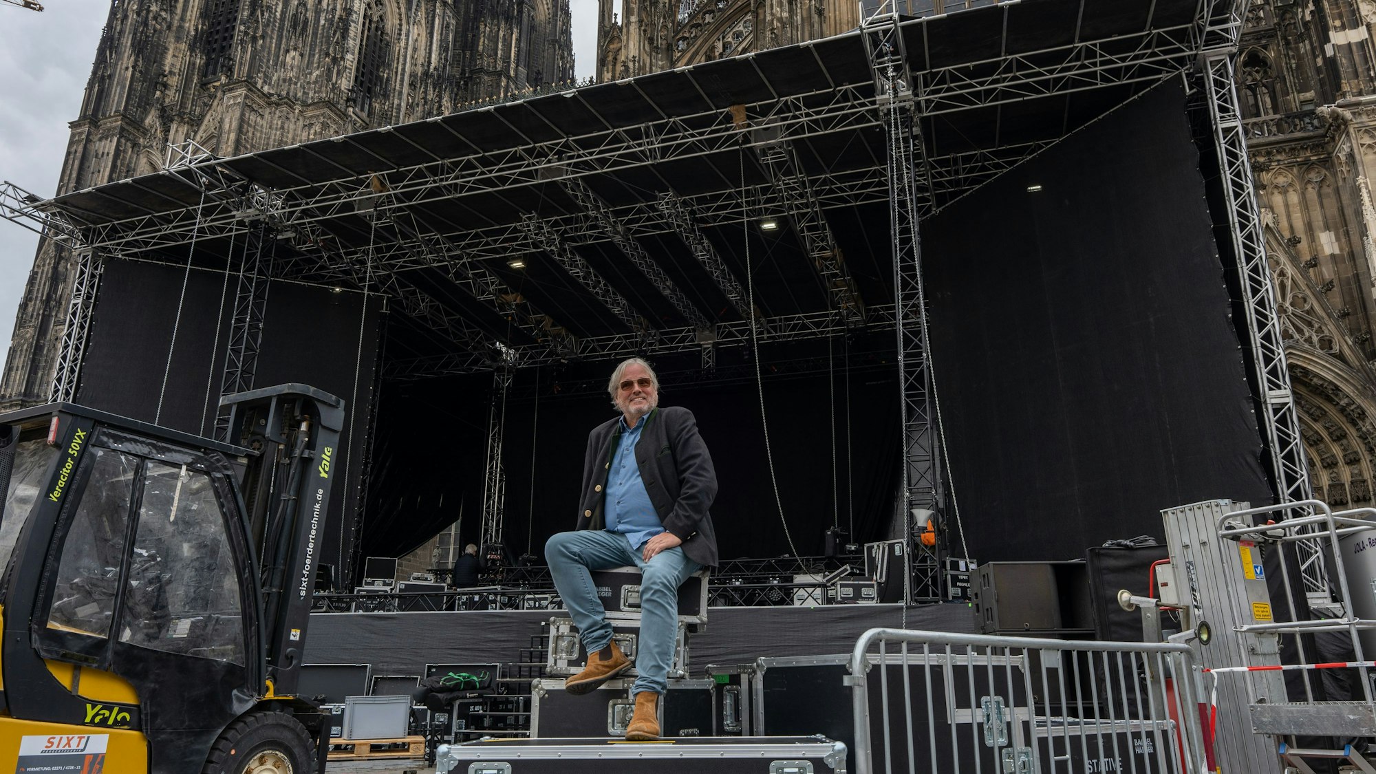 Ernst-Ludwig Hartz sitzt vor der Bühne, auf der ab Mittwoch Weltstars im Schatten des Doms spielen.
