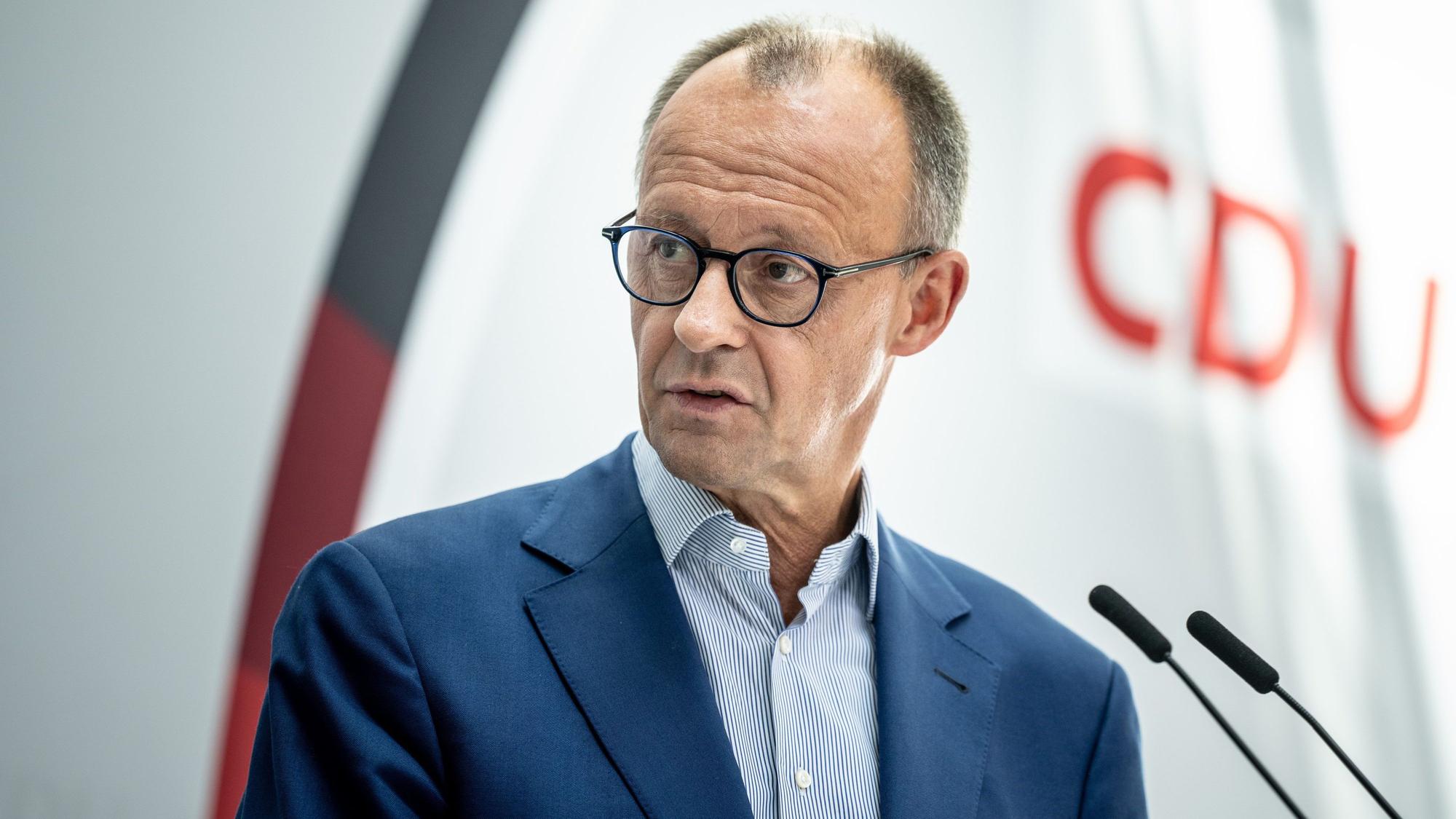 CDU-Bundesparteichef Friedrich Merz steht vor Mikrofonen.