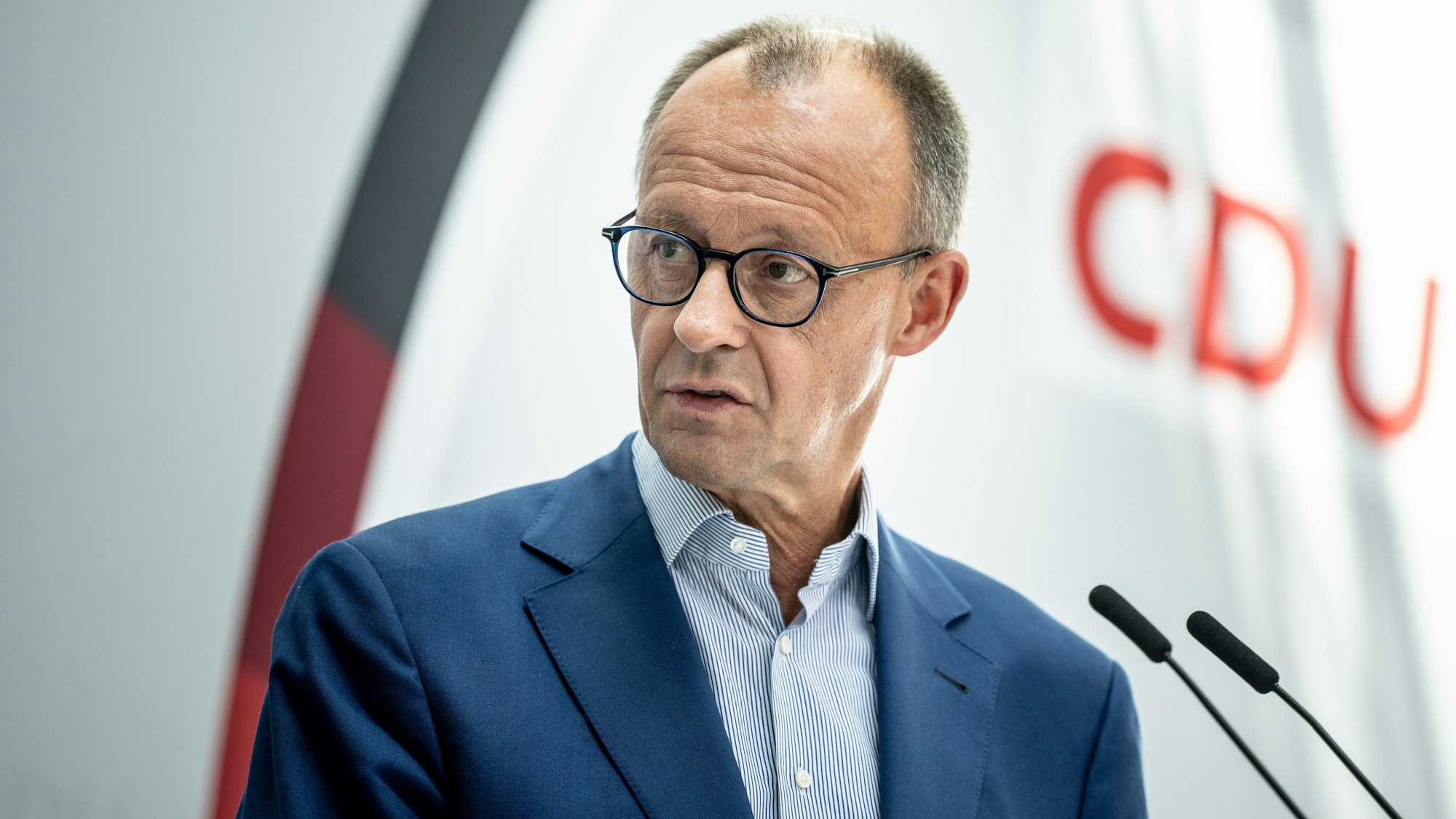 CDU-Bundesparteichef Friedrich Merz steht vor Mikrofonen.